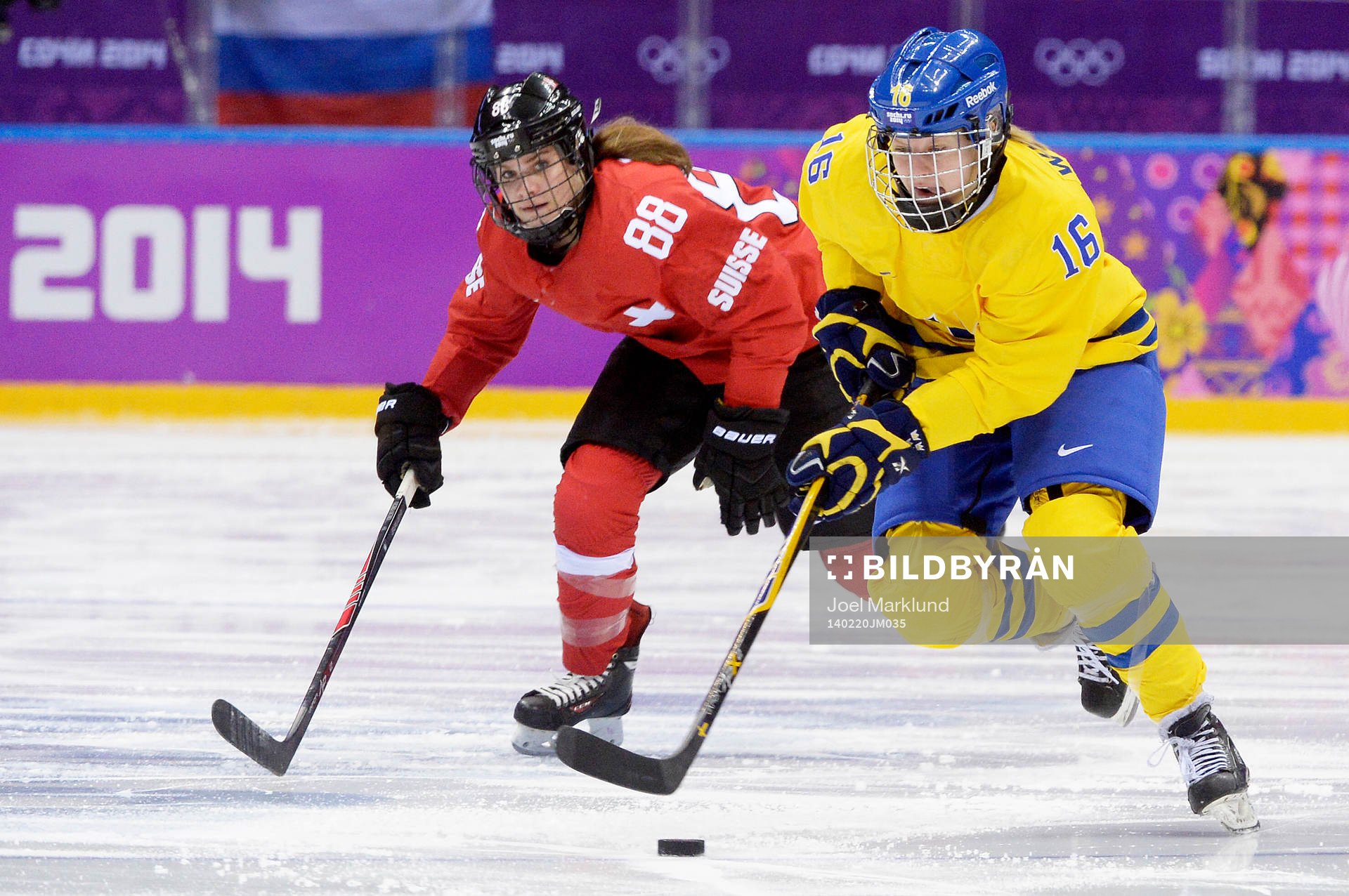 Sveriges Pernilla Winberg åker med pucken och Schweiz