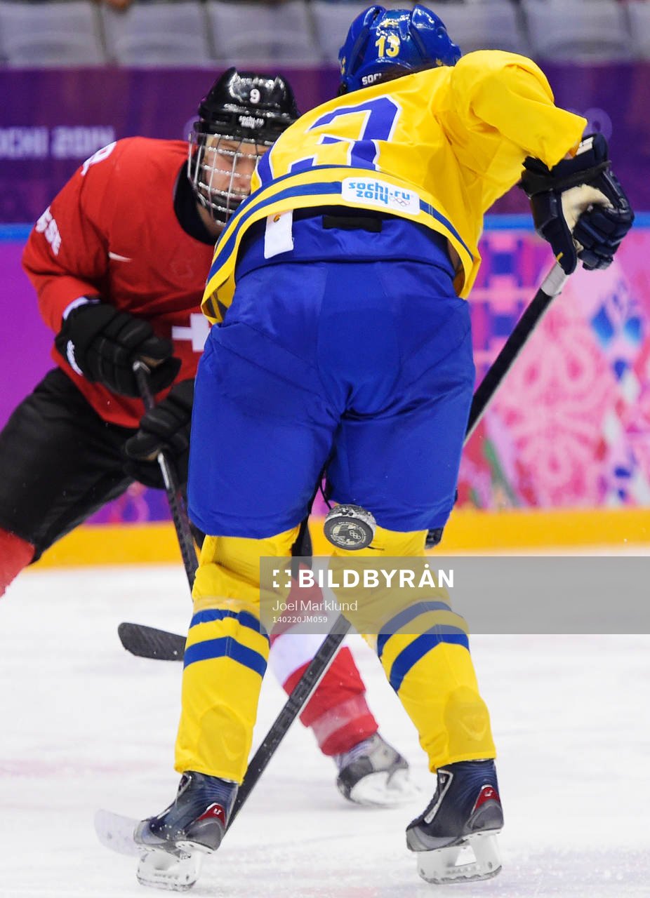 Schweiz Stefanie Marty skjuter en pucken mellan benen på