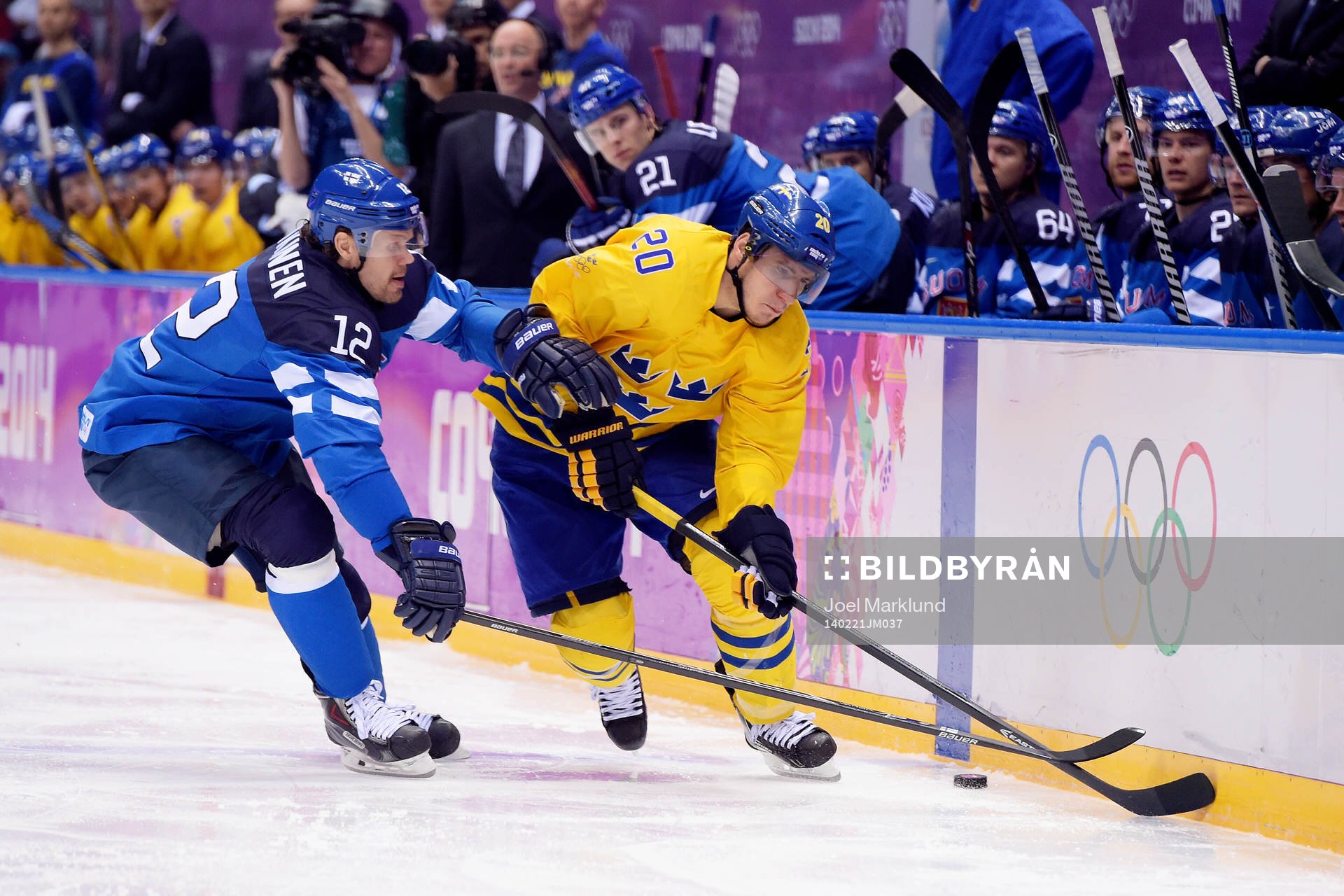 Sveriges Alexander Steen kämpar för pucken med Finlands