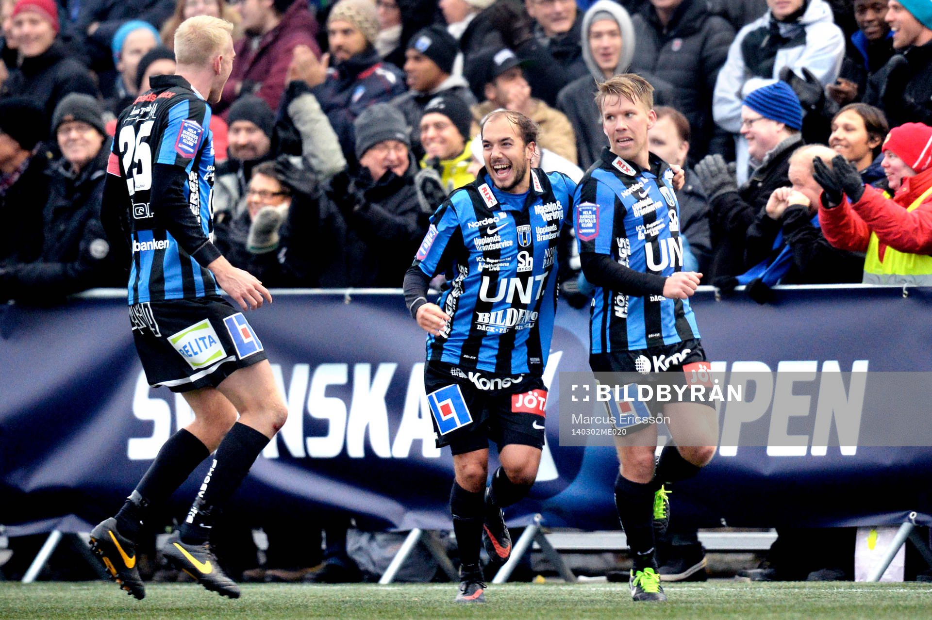 Sirius Karl Larson (mitten) kramar om Joakim Runnemo (th) som gjort 2-1 under fotbollsmatchen mellan Sirius och Djurgården i Svenska Cupen den 02 mars 2014 i Stockholm.