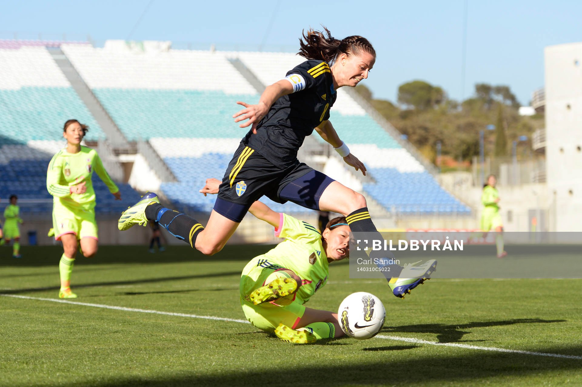 Lotta Schelin flyger fram under fotbollsmatchen mellan Japan och Sverige i Algarve Cup den 10 mars 2014. Iwashimizu Azusa försöker stoppa henne.