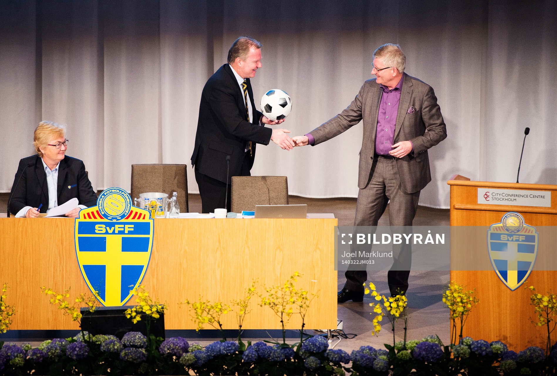 Karl-Erik Nilsson, ordförande, tar emot en fotboll av Hans Bredberg, advokat, under Svenska Fotbollförbundets årsmöte den 22 mars 2014 i Stockholm.