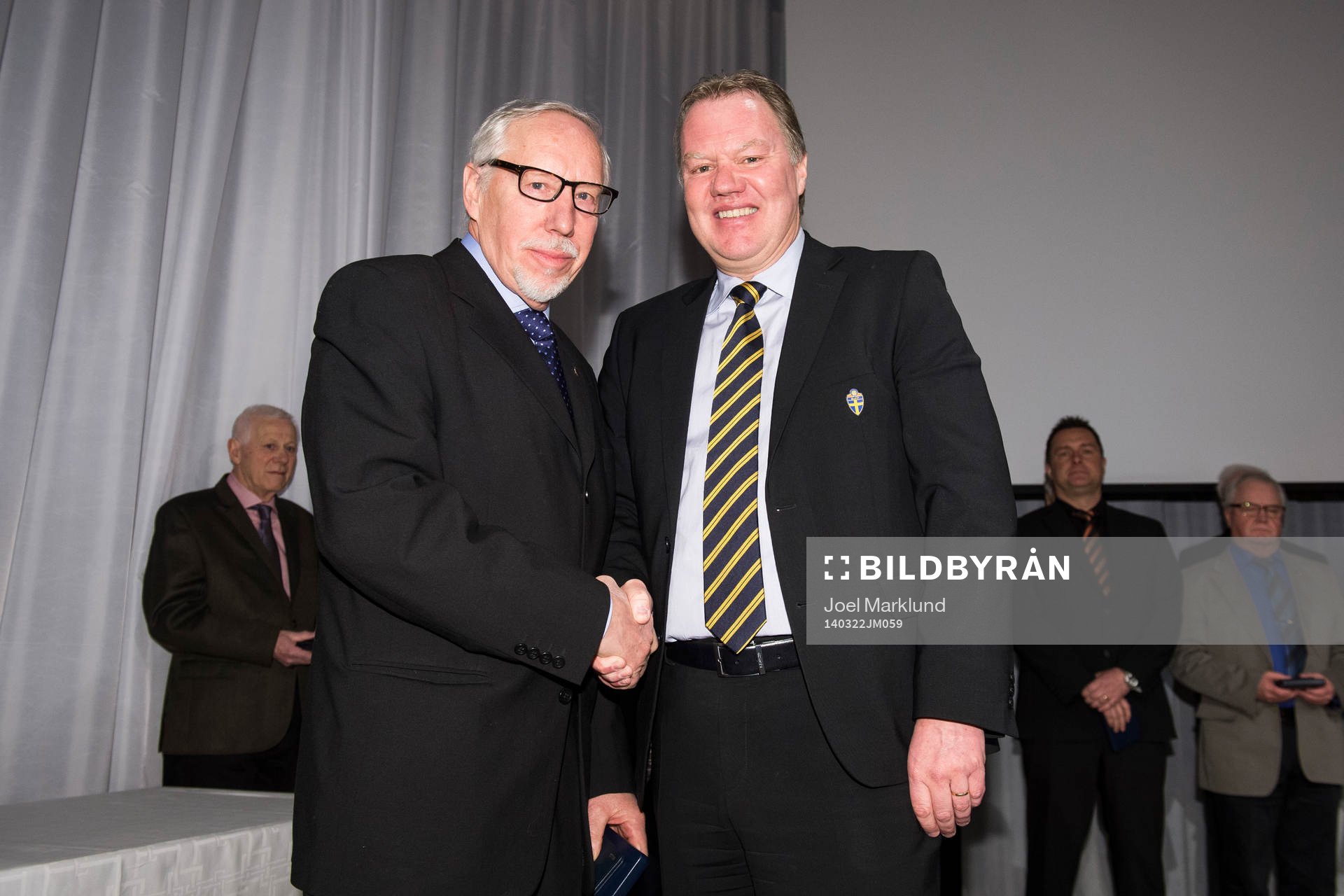 Ronny Söderlund tar emot en medalj för sina insatser av Karl-Erik Nilsson, ordförande SvFF, under Svenska Fotbollförbundets årsmöte den 22 mars 2014 i Stockholm.