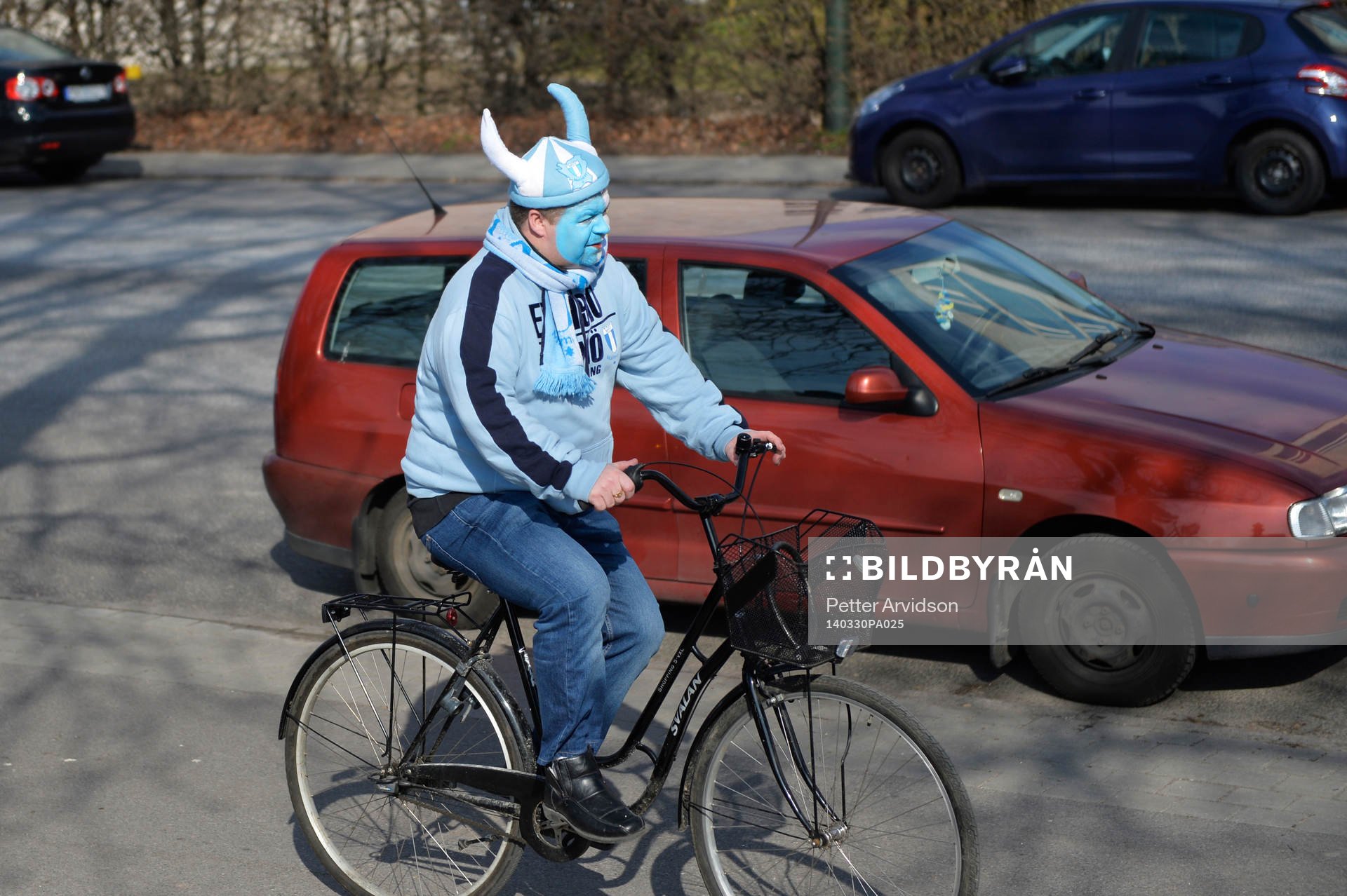En målad Malmö supporter kommer cuklande till matchen