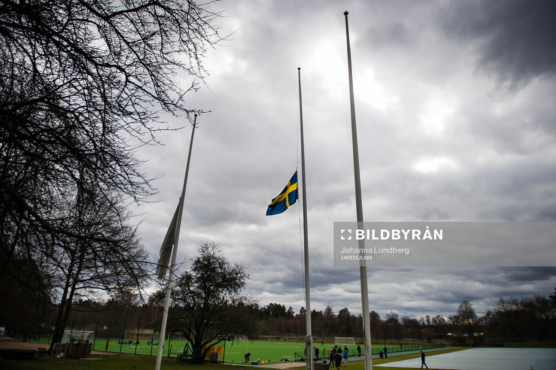 En svensk flagga och en Djurgårdsflagga hänger på halv