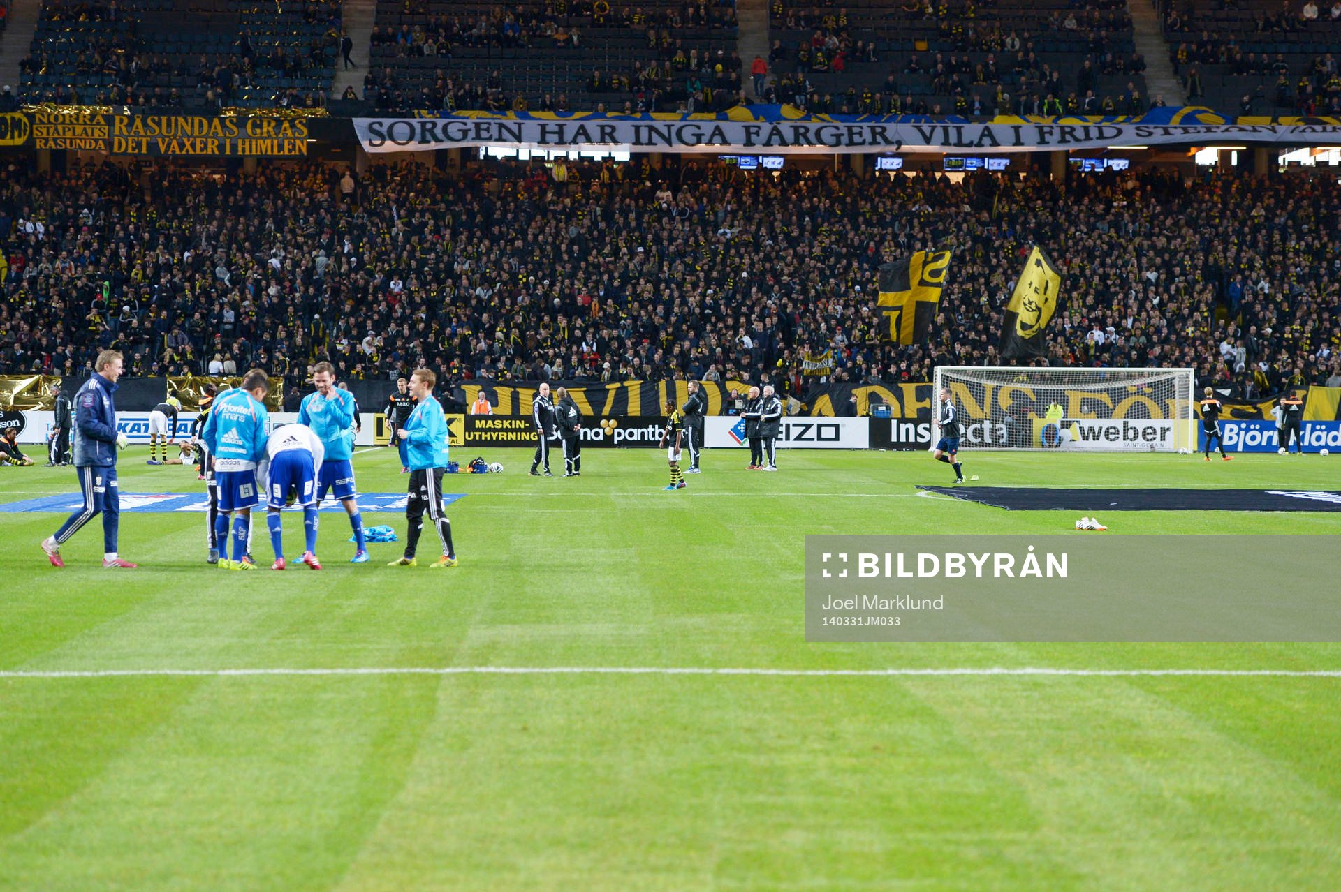 Spelarna värmer upp med banderollen Sorgen har inga