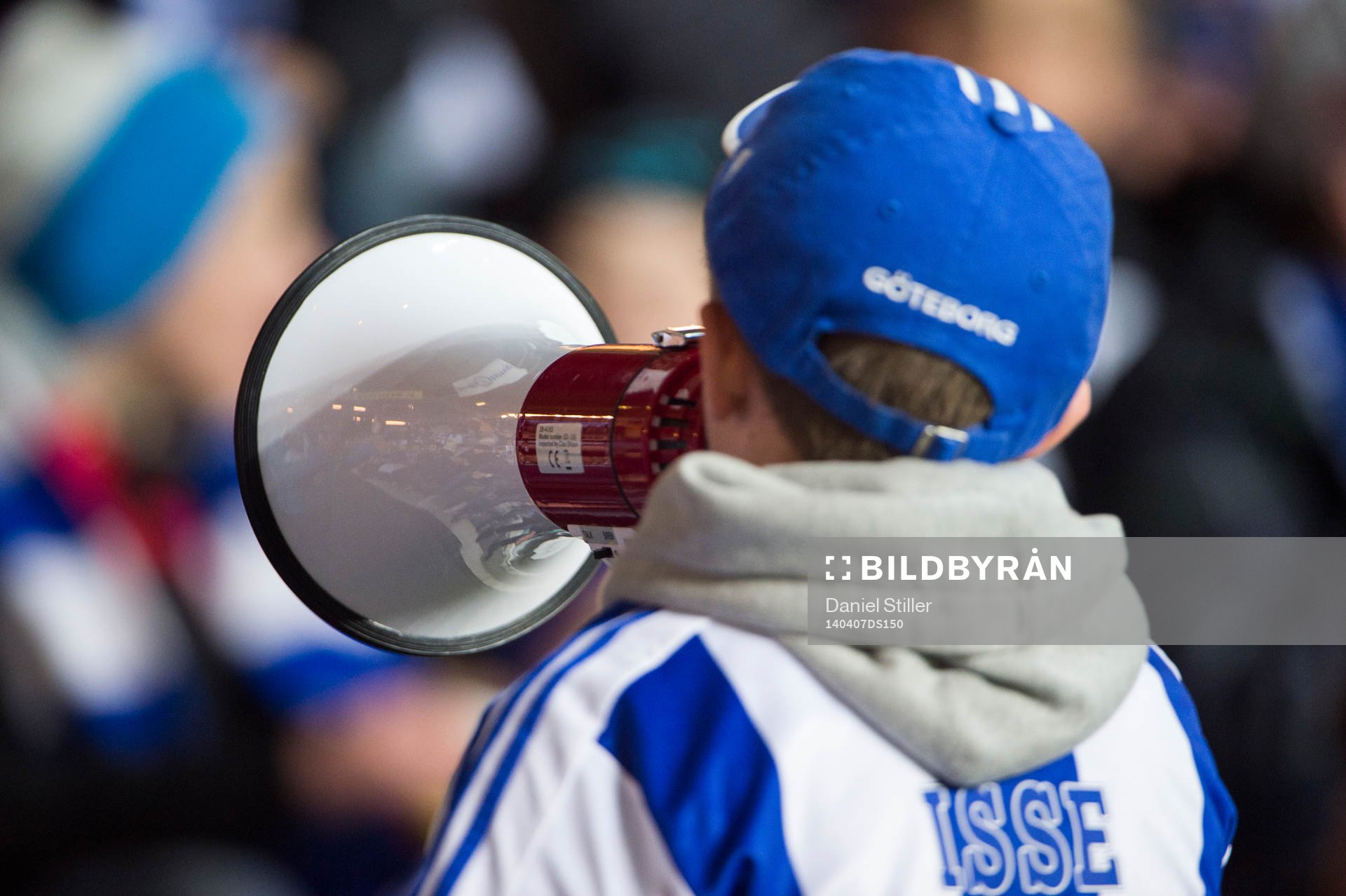 En ung blåvitt-supporter med megafon
