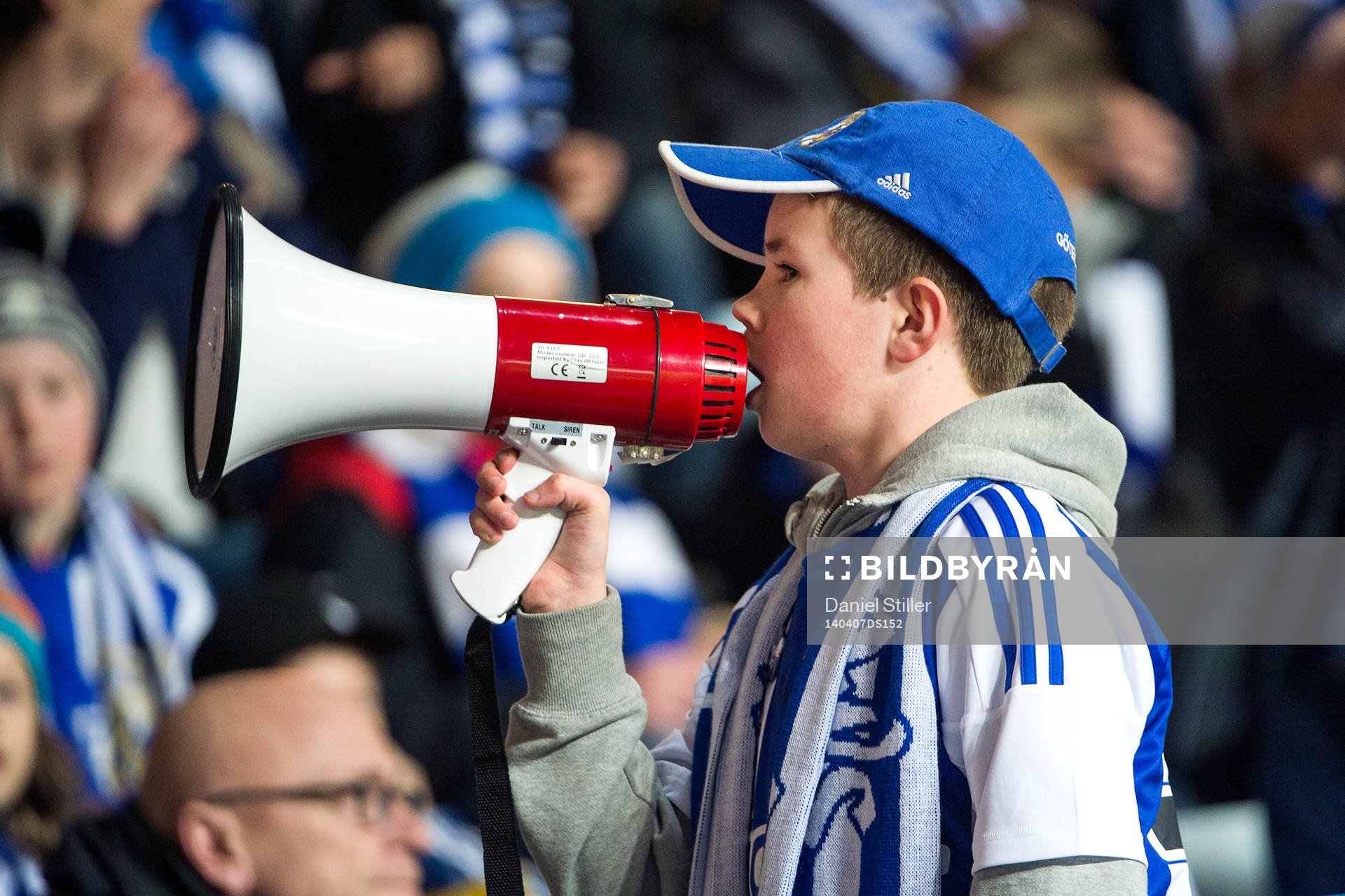 En ung blåvitt-supporter med megafon
