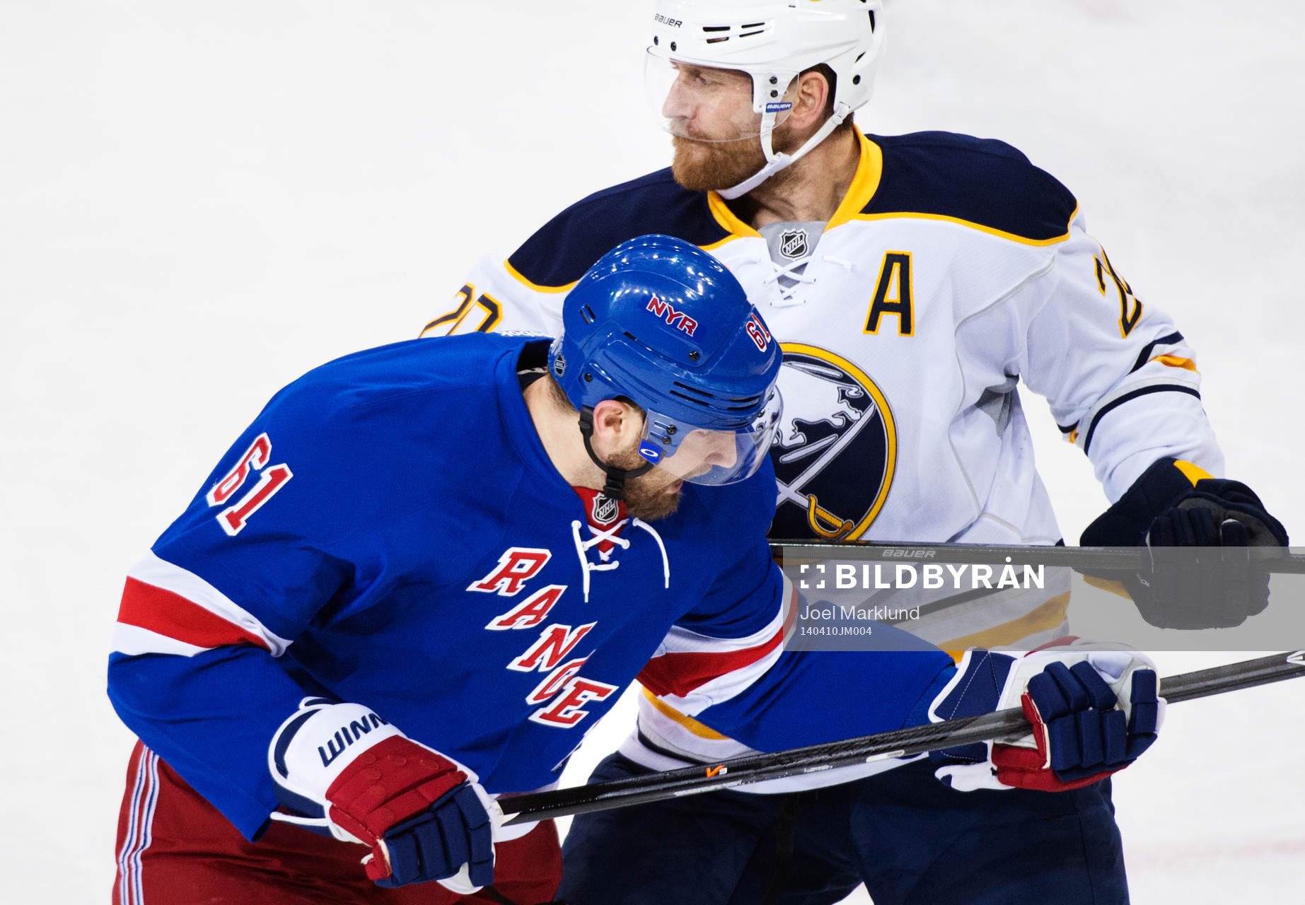 Buffalos Henrik Tallinder (t h) tacklar New Yorks Rick Nash