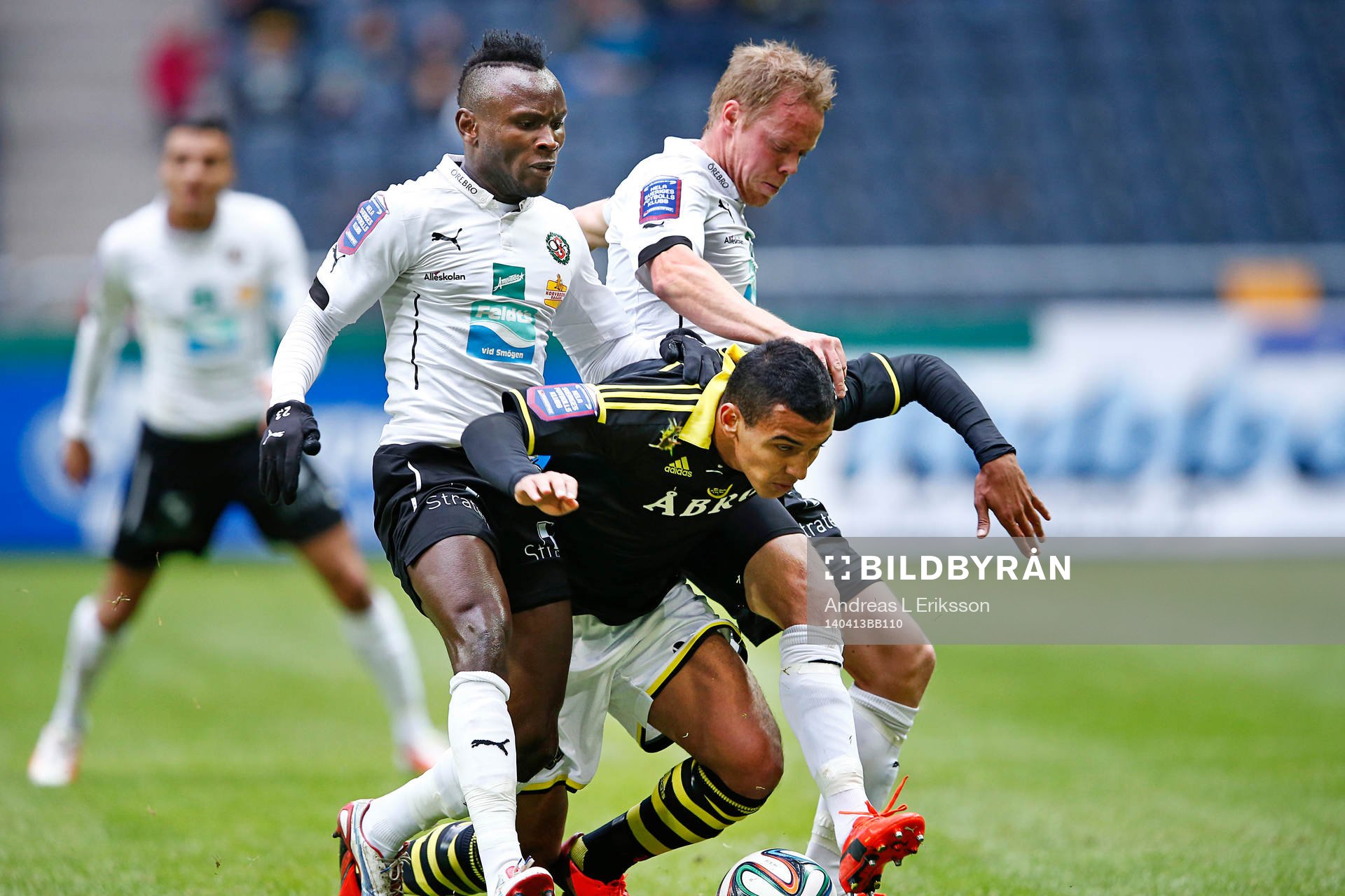 Örebros Patrik Haginge och Ayanda Nkili fäller AIK:s Nabil Bahoui under fotbollsmatchen i Allsvenskan mellan AIK och Örebro den 13 april 2014 i Stockholm. 