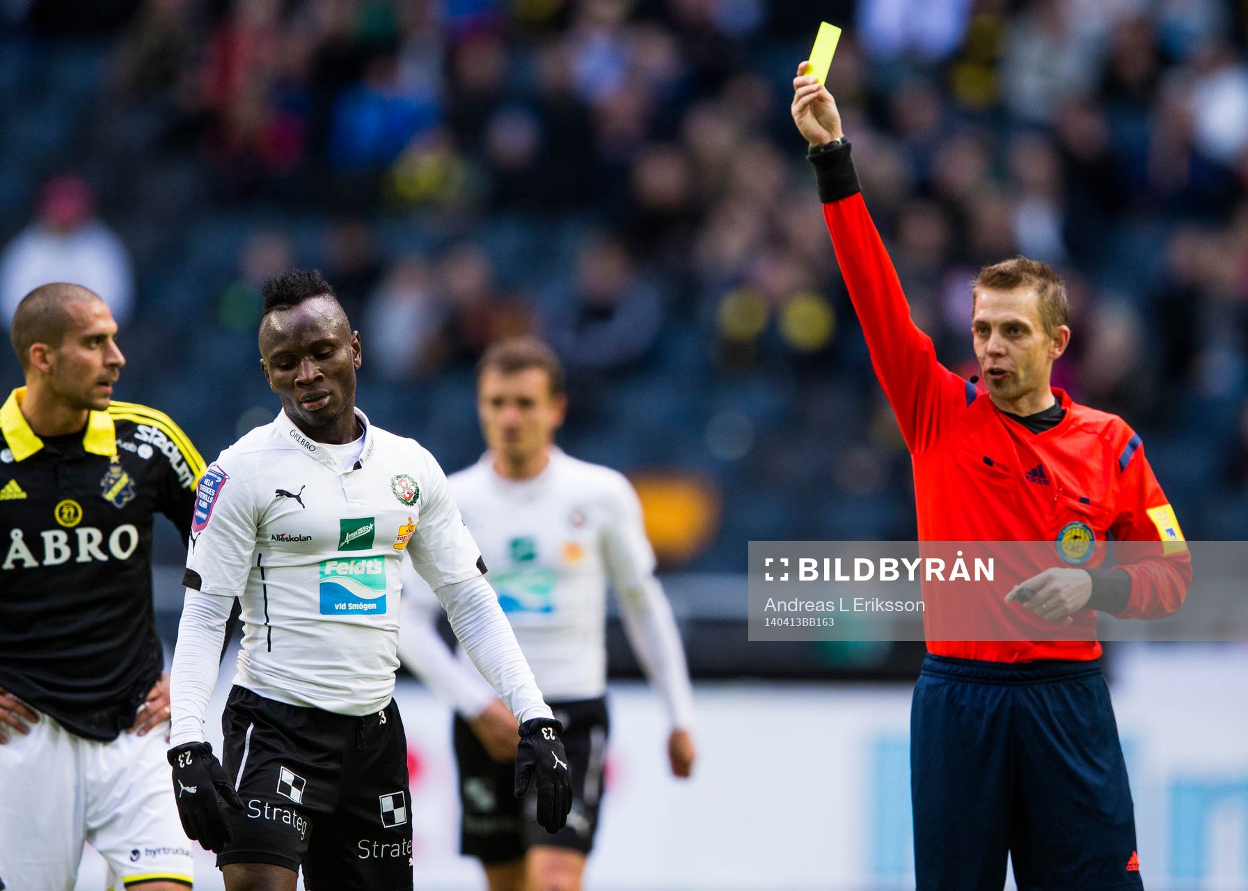Örebros Samuel Mensiro får ett gultkort av domare Johan
