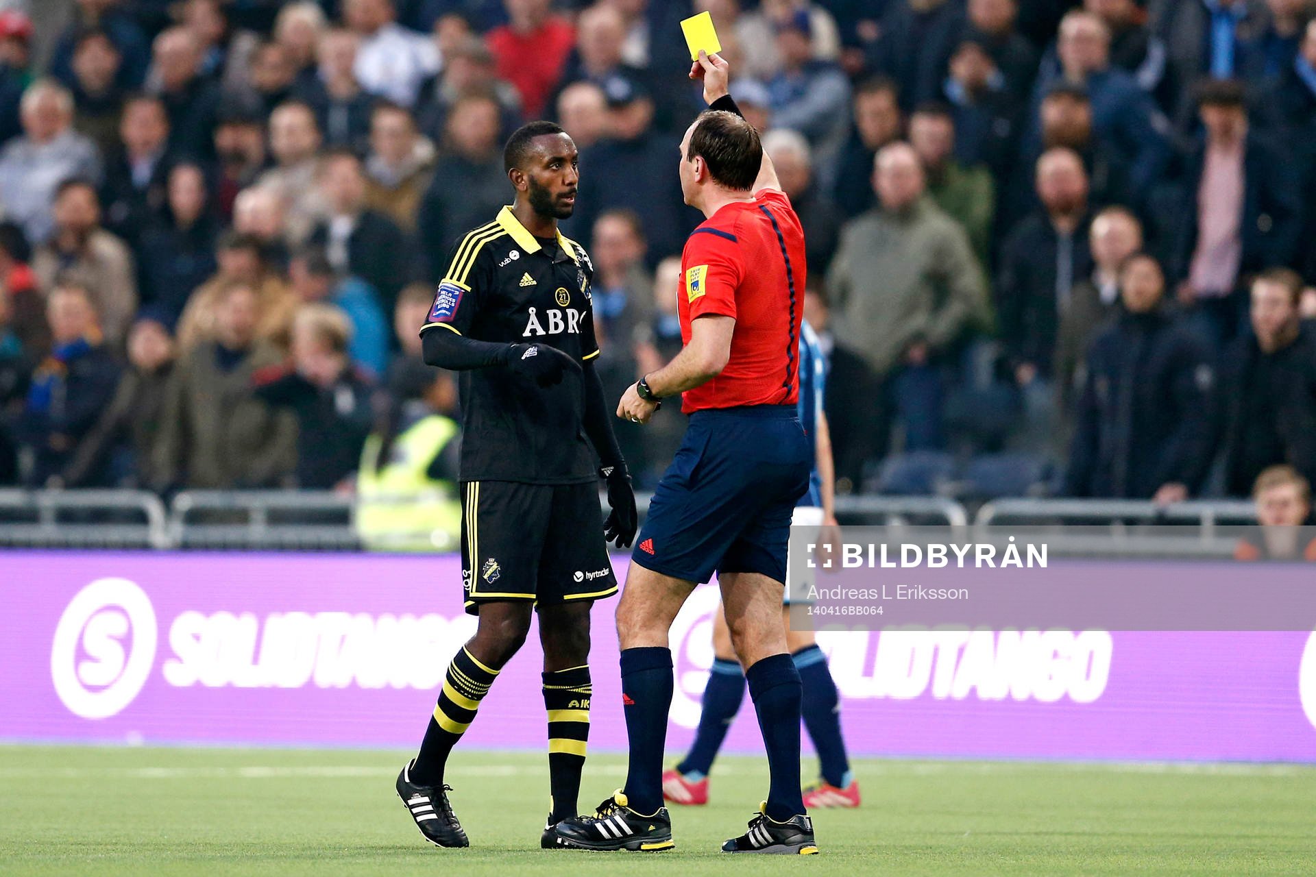 AIK:s Henok Goitom får gult kort av domare Jonas Eriksson under fotbollsmatchen i Allsvenskan mellan Djurgården och AIK den 16 april 2014 i Stockholm.