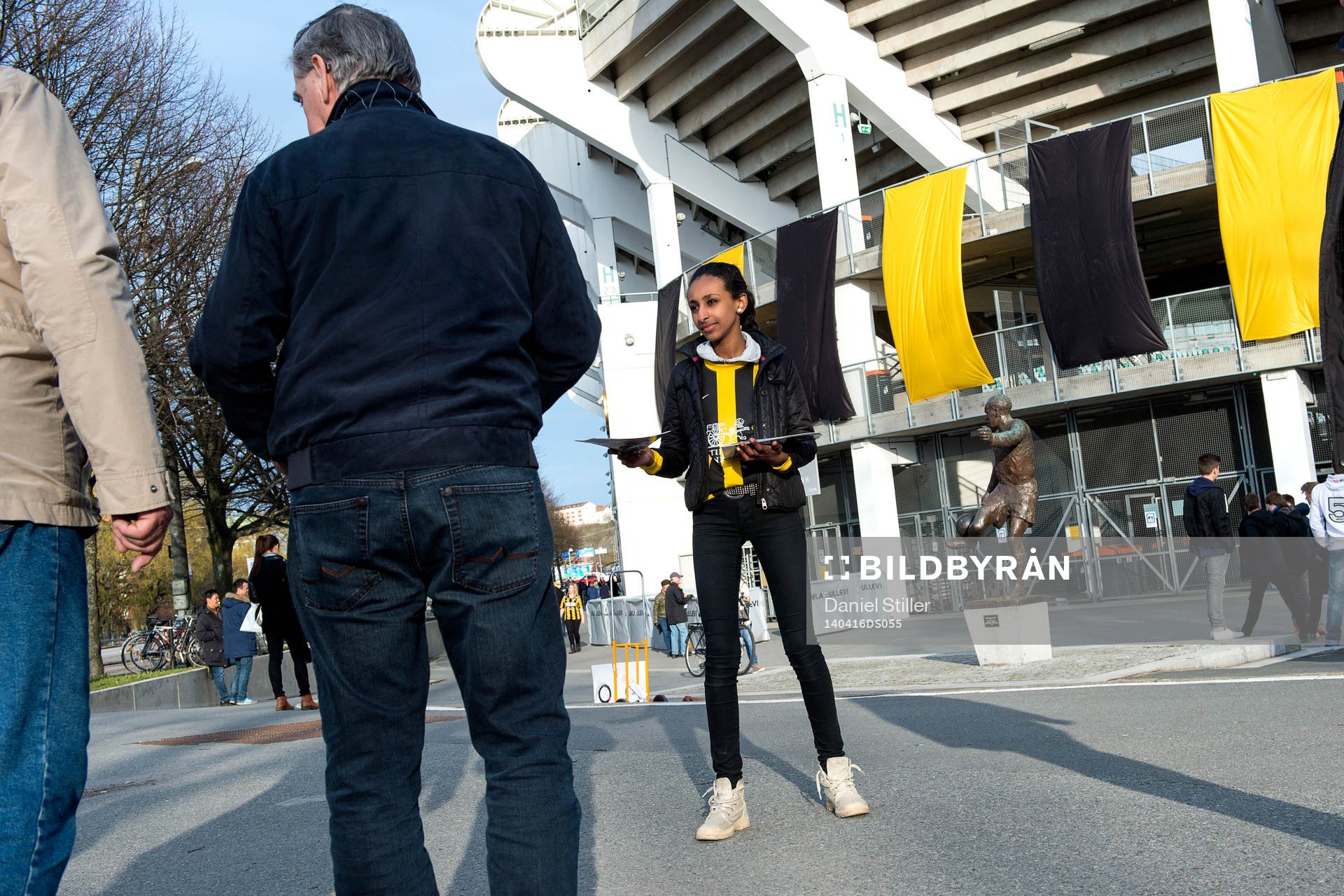 Unga volontärer med matchprogram utanför arenan innan