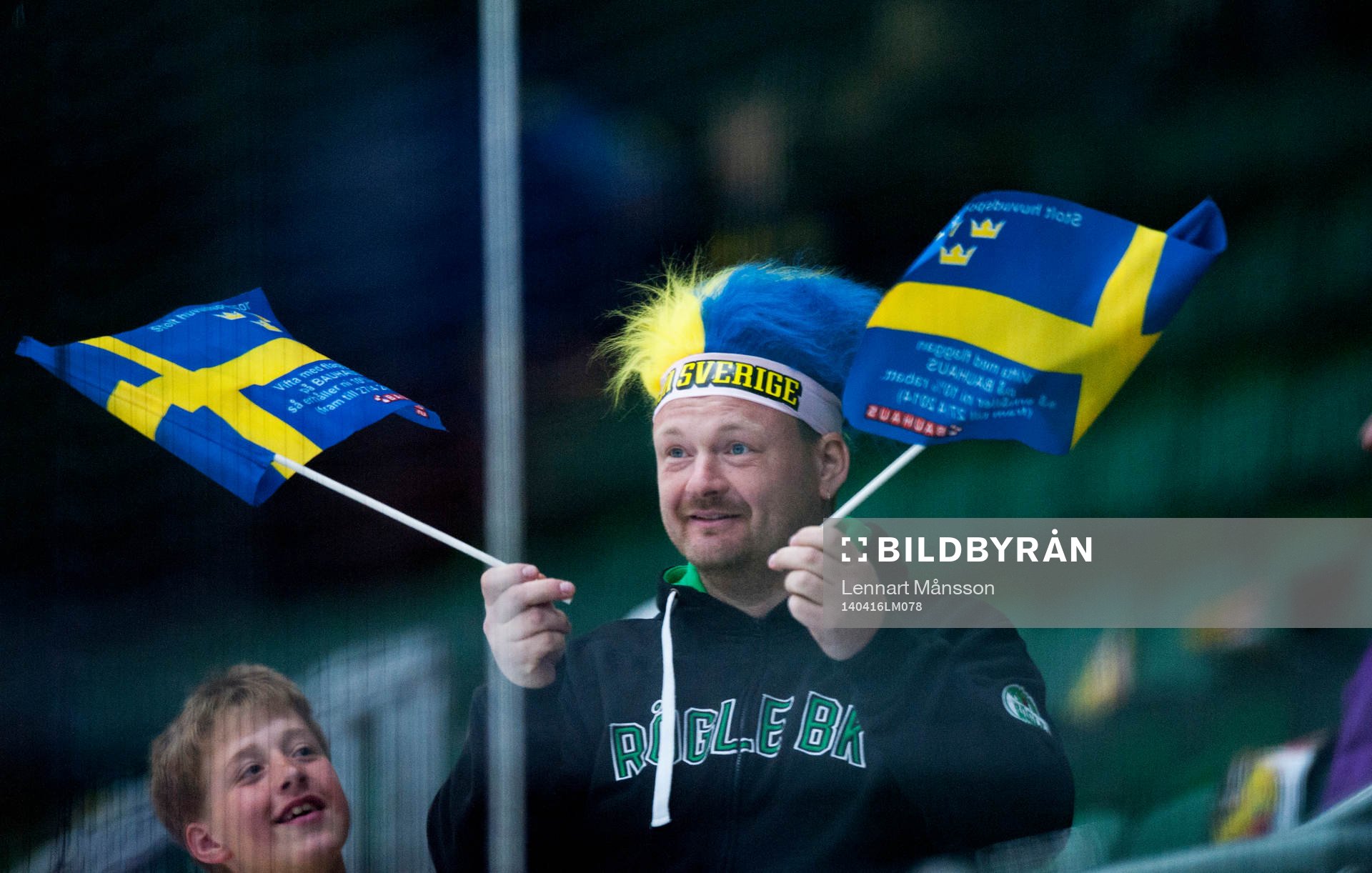 Svensk supporter med svenska flaggor i ishockeylandskampen