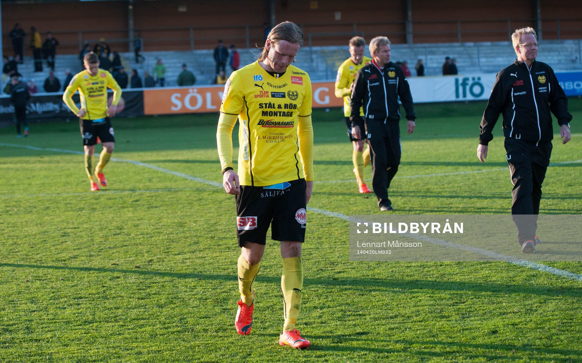 Mjällbys Gudmann Thorisson och tränaren Lars Jacobsson lämnar planen i matchen i allsvenskan mellan Mjällby och Häcken i Hällevik 20 april 2014.