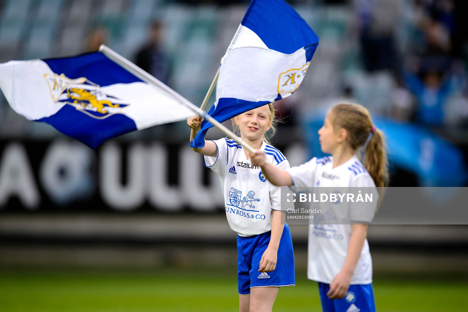 Två tjejer viftar med flaggor innan fotbollsmatchen i Allsvenskan mellan IFK Göteborg och Falkenberg den 25 april 2014 i Göteborg.