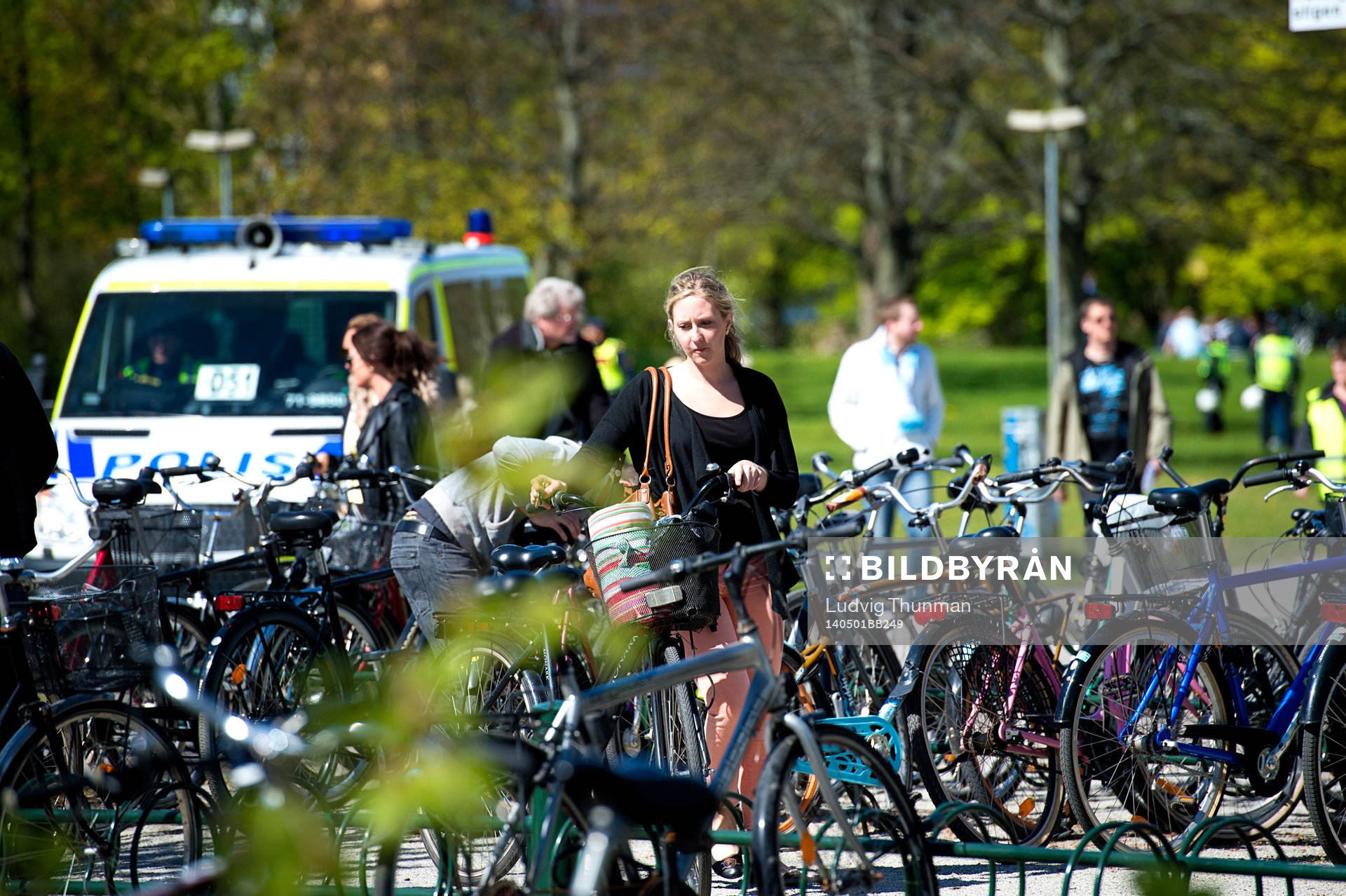 En kvinna parkerar en cykel i ett cykelställ