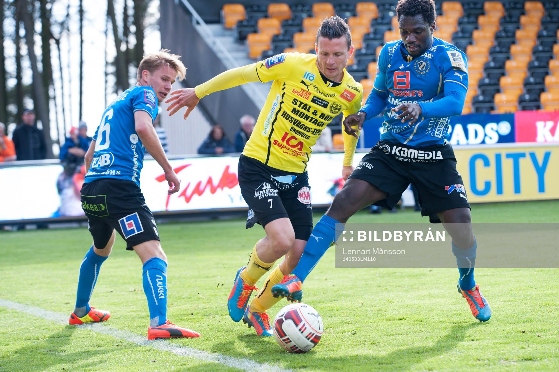 Mjällbys Kristian Haynes mot Halmstads Johan Blomberg och King Osei Gyan i matchen i allsvenskan mellan Mjällby och Halmstad i Hällevik 3 maj 2014.