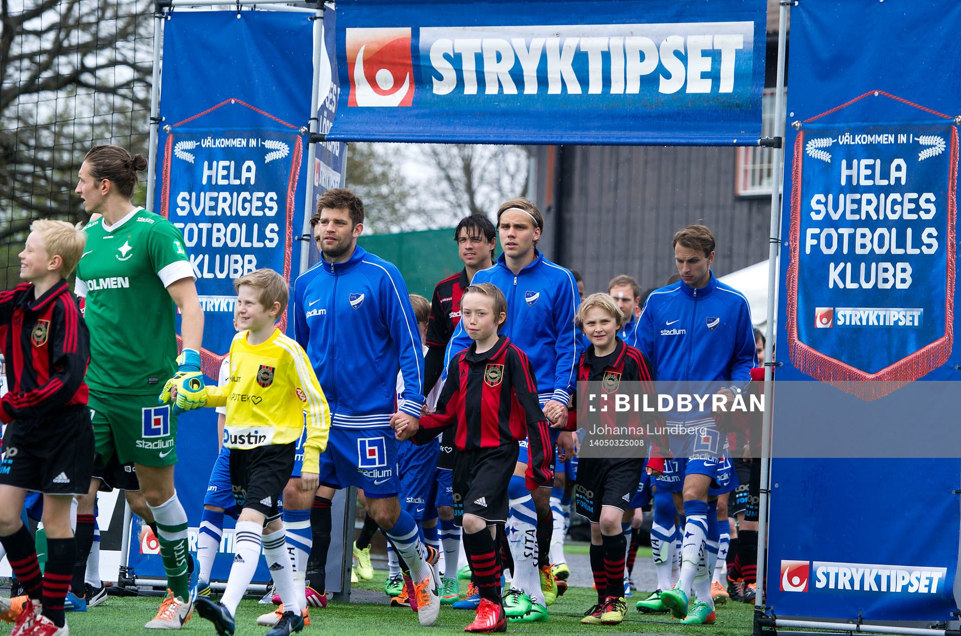 Spelare går in på planen innan fotbollsmatchen i