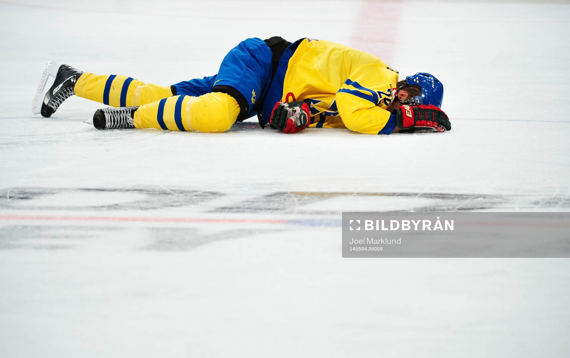 Sveriges Dick Axelsson ligger på isen skadad