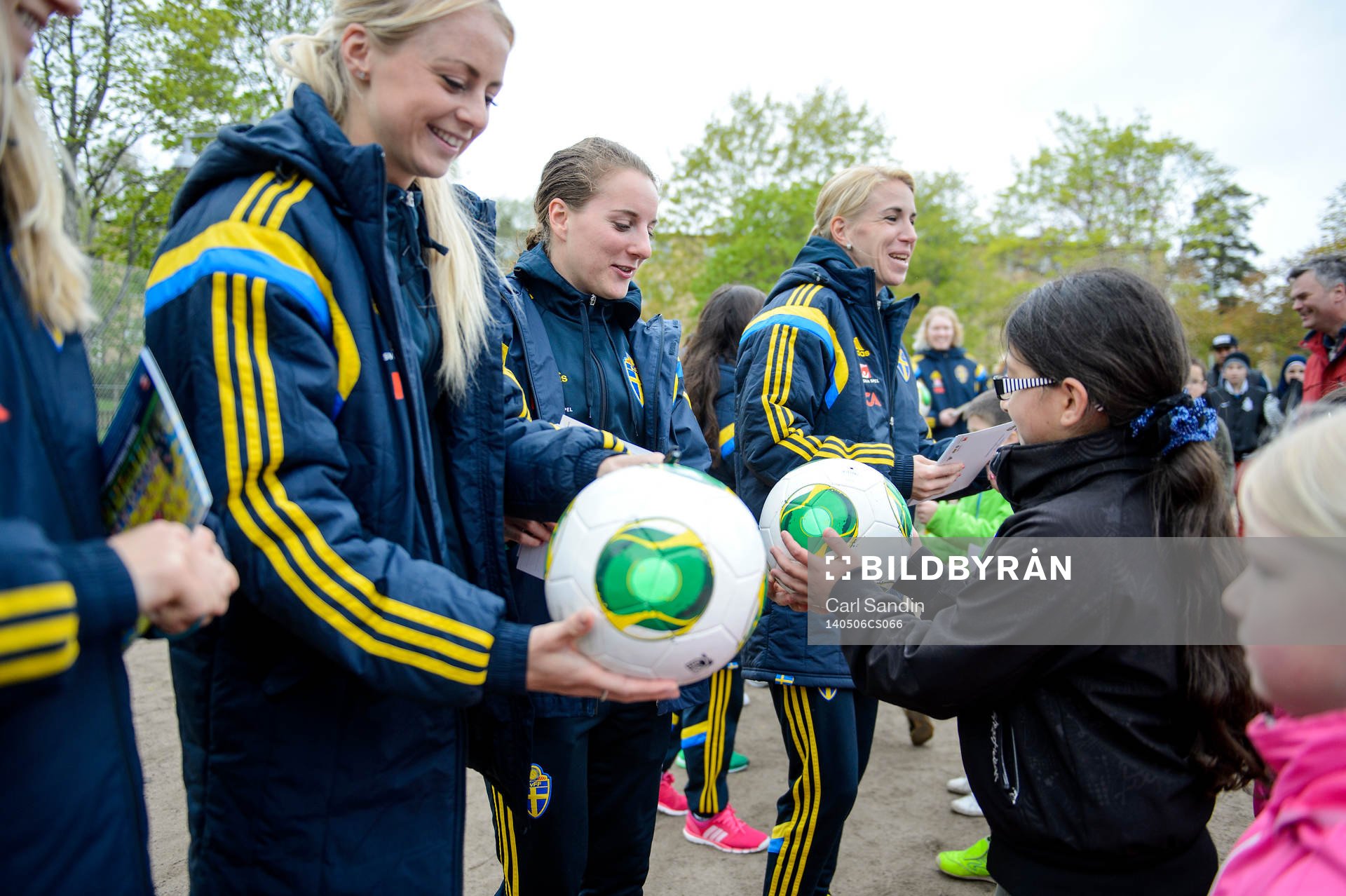 Sveriges Amanda Ilestedt, Antonia Göransson och Elin Magnusson överlämnar bollar till barnen på en skola den 6 maj 2014 i Växjö.