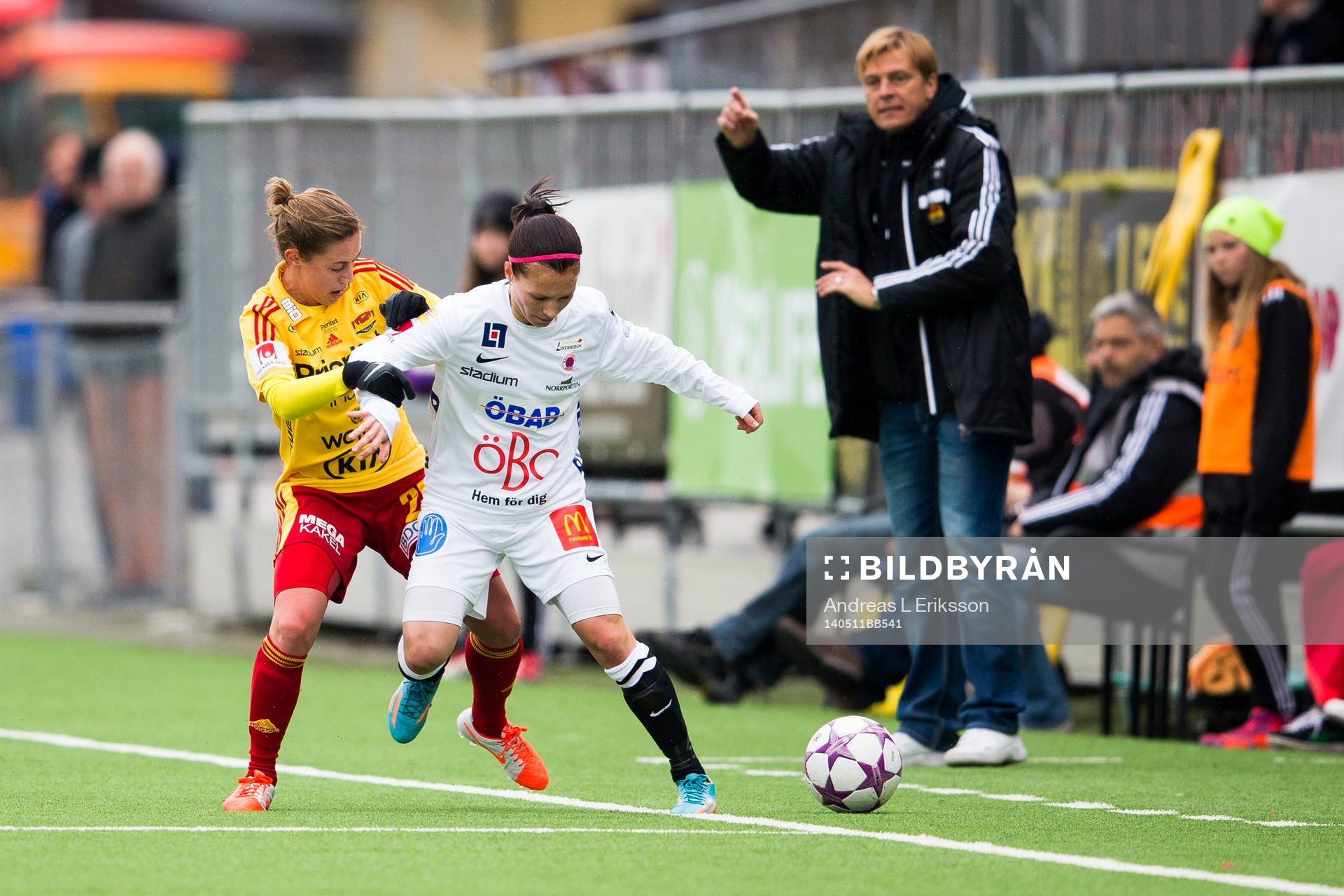 Meghan Klingenberg i kamp om bollen Örebros Susanna Lehtinen medan Tyresös tränare Tony Gustavsson dirigerar sina spelare under fotbollsmatchen i Damallsvenskan mellan Tyresö och Örebro den 11 maj 2014 i Stockholm. 