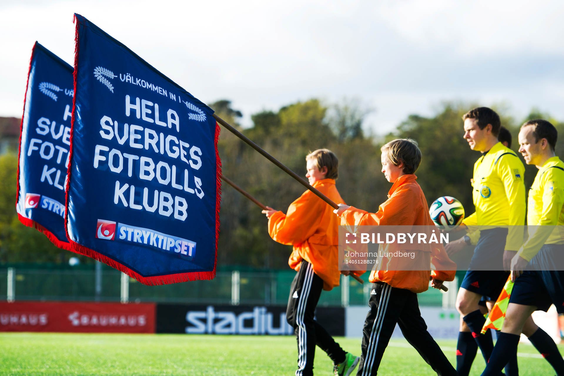 Bollkallar går in på planen bärandes flaggor