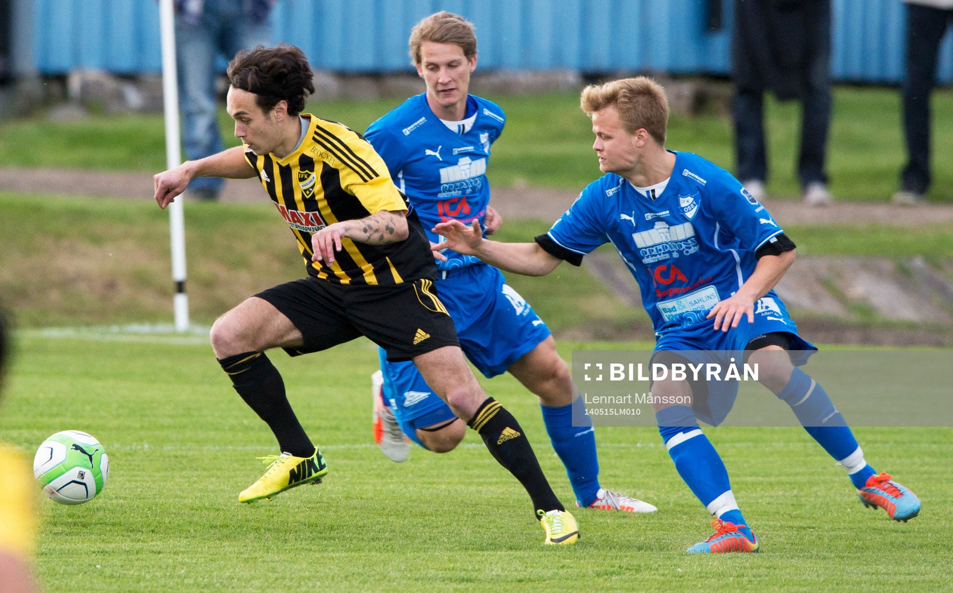 Hässleholms Karim Al-Asi steget före Osbys Jacob Lang i matchen i division 3 mellan IFK Osby och IFK Hässleholm i Osby 15 maj  2014.