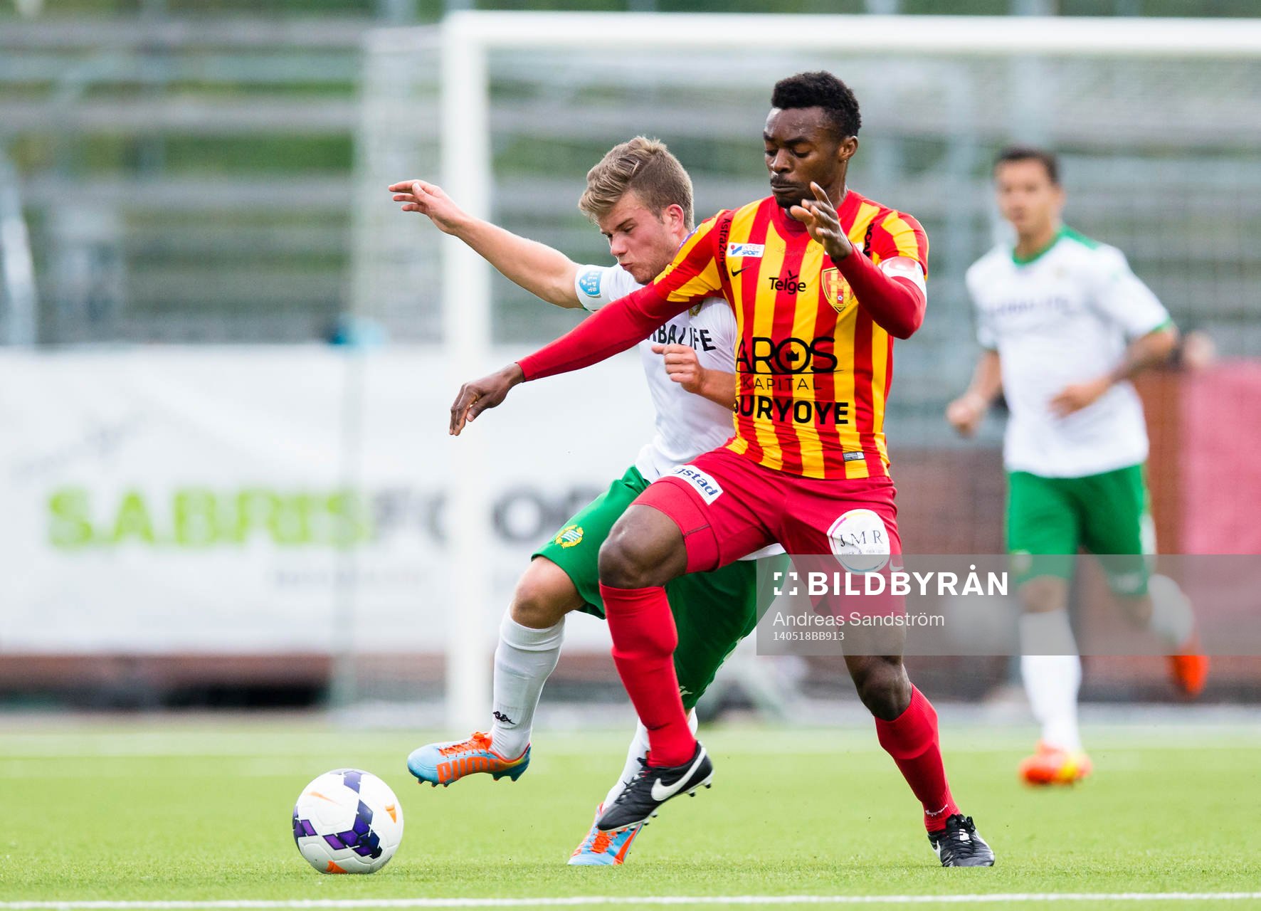 Syrianskas Success Chimankpa Nwosu i kamp med Hammarbys Nicklas Lindqvist under fotbollsmatchen i Superettan mellan Syrianska och Hammarby den 18 Maj 2014 i Södertälje.