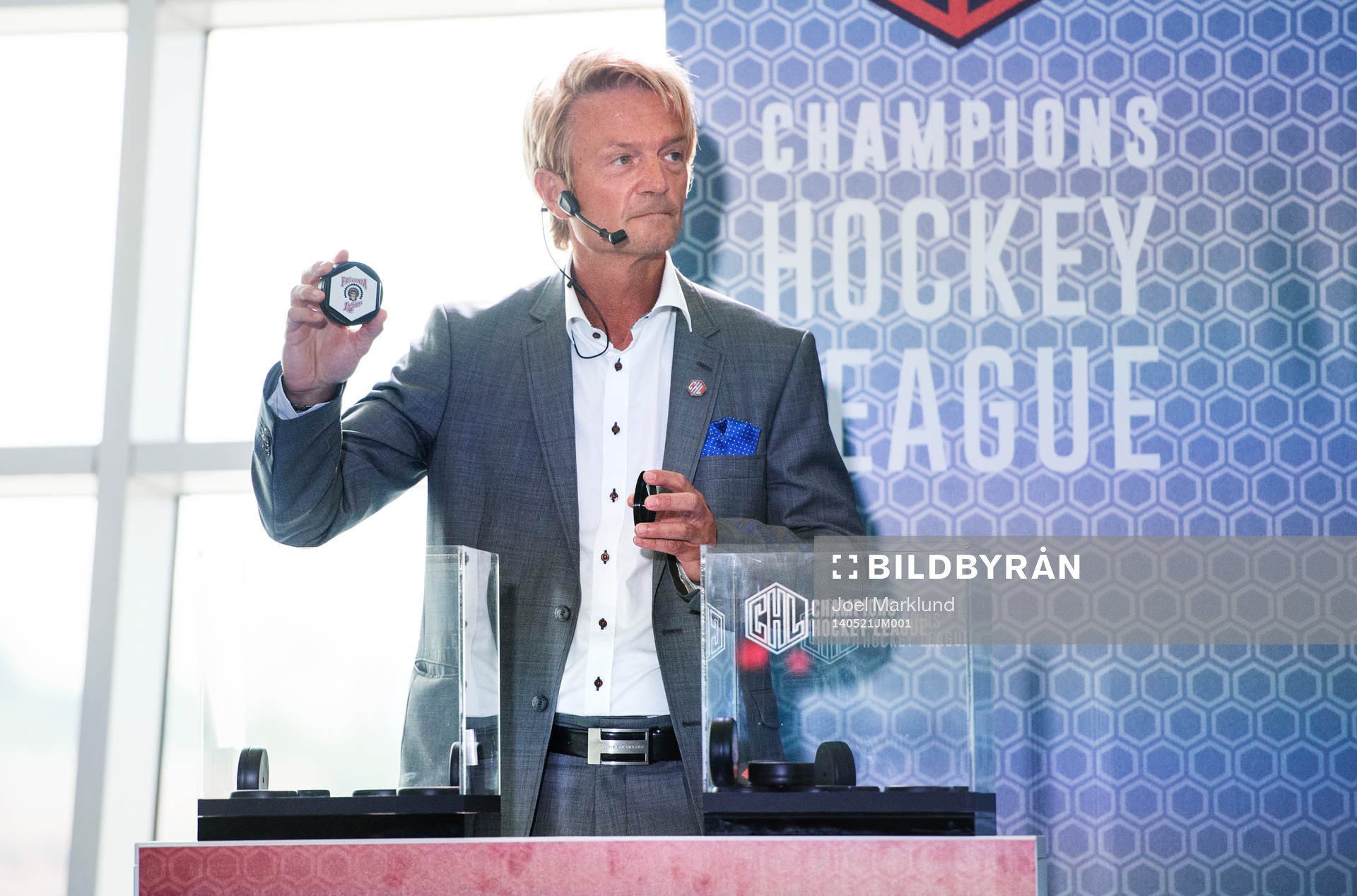 s ordförande Anders Ternbom håller upp en puck för