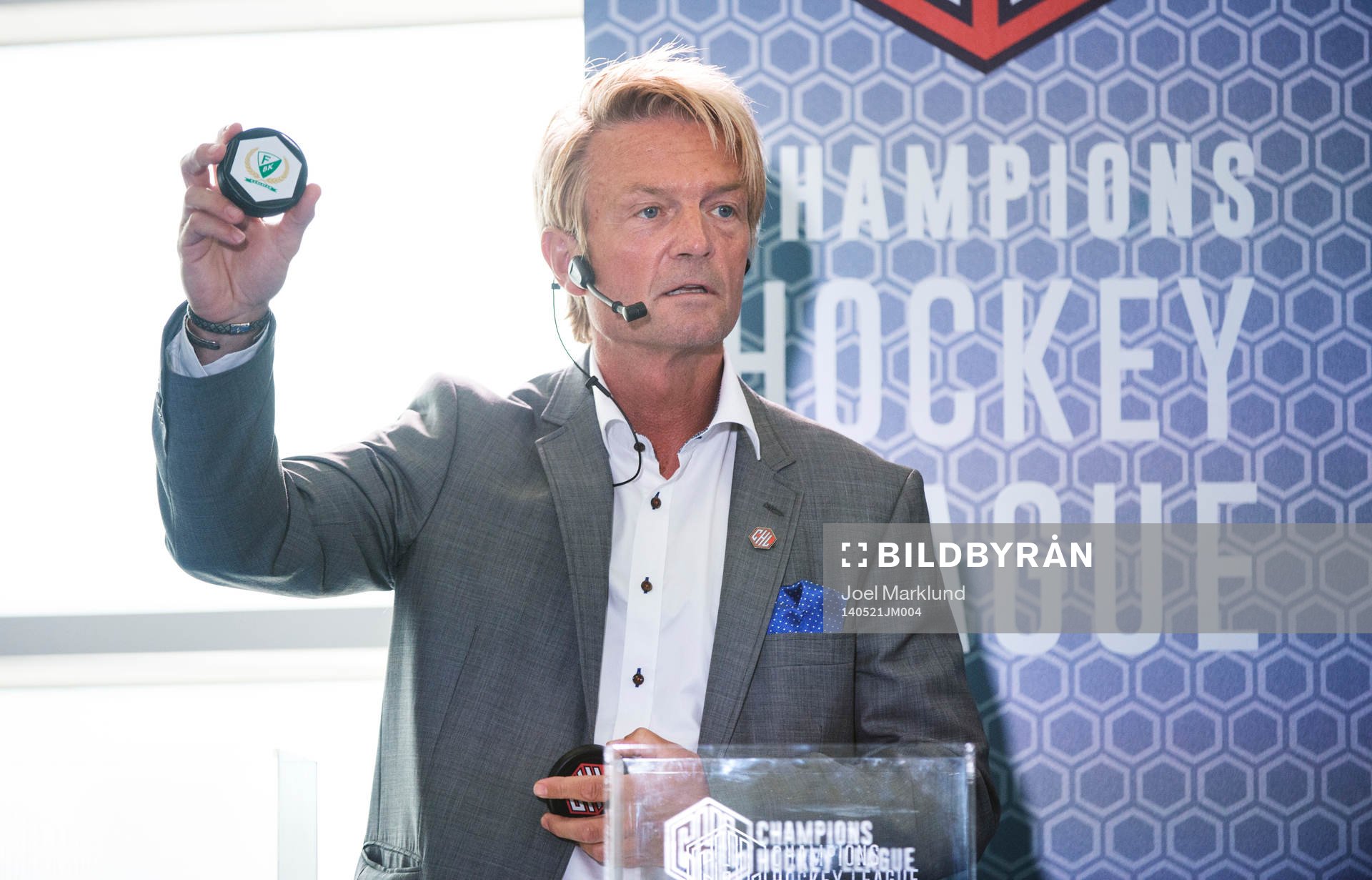 s ordförande Anders Ternbom håller upp en puck för