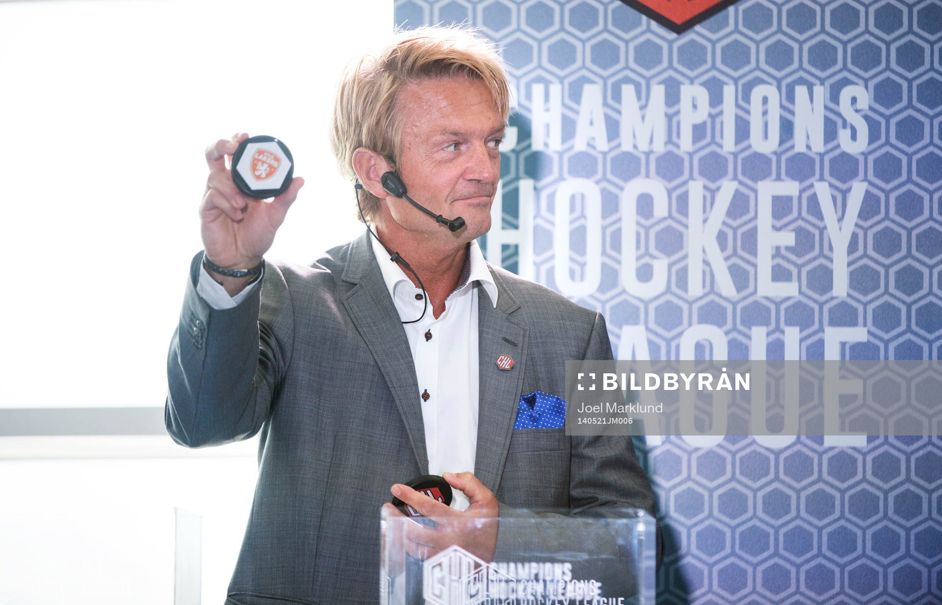 s ordförande Anders Ternbom håller upp en puck för