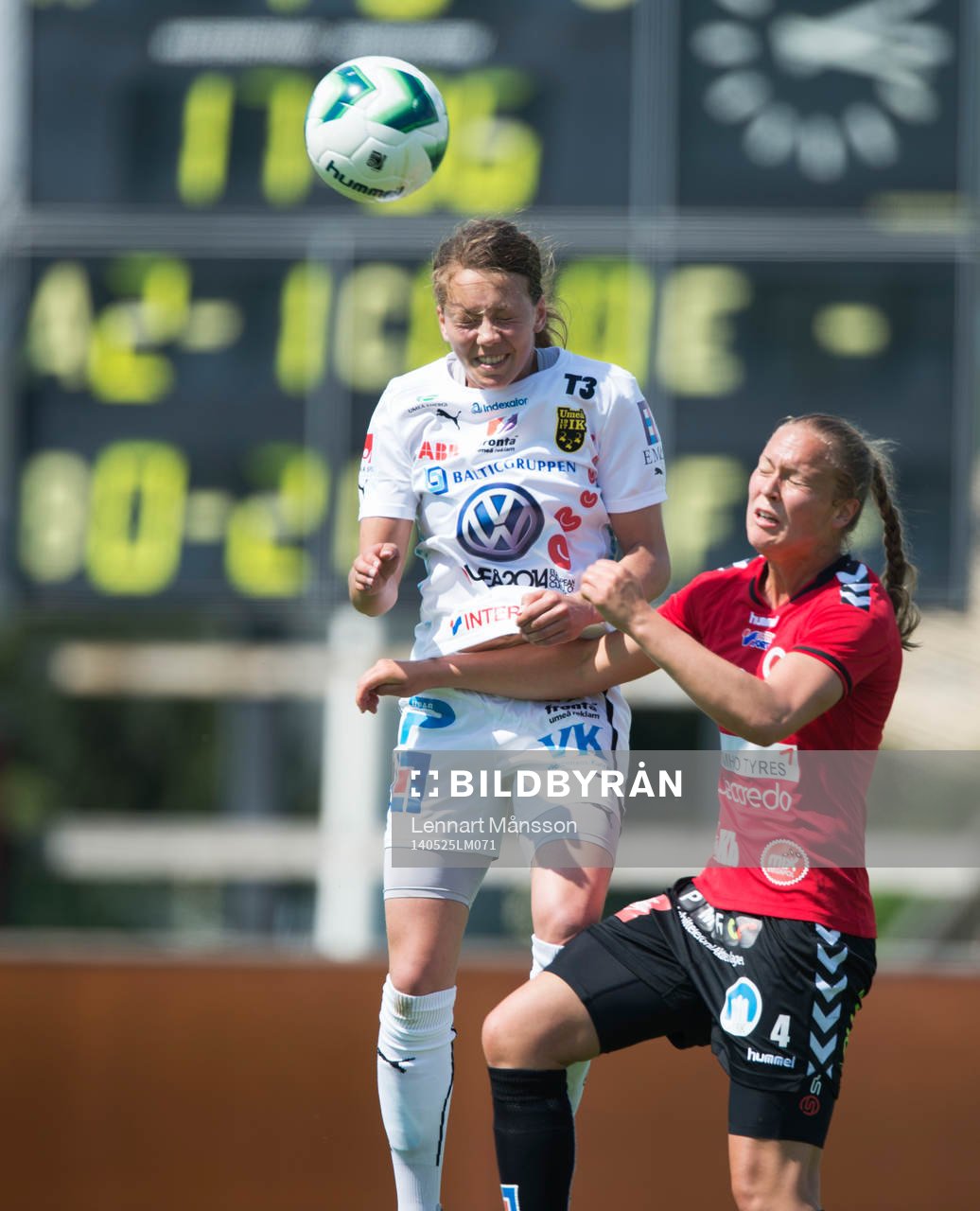 Höjdduell mellan Umeås Elin Landström och Kristianstads Therese Andersson med matchtavlan i bakgrunden i matchen i damallsvenskan mellan Kristianstad och Umeå i Kristianstad 25 maj 2014.