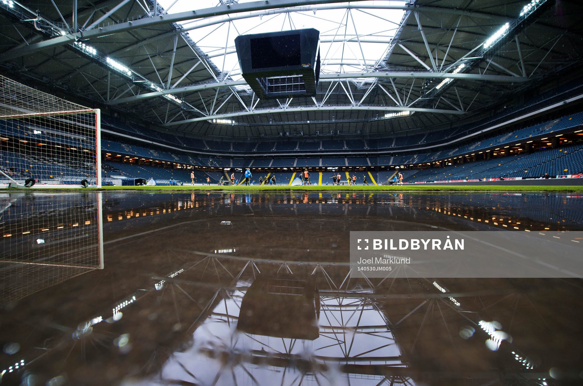 Friends Arena speglas i vatten som regnat in under Sveriges fotbollandslags träning den 30 maj 2014 i Stockholm.