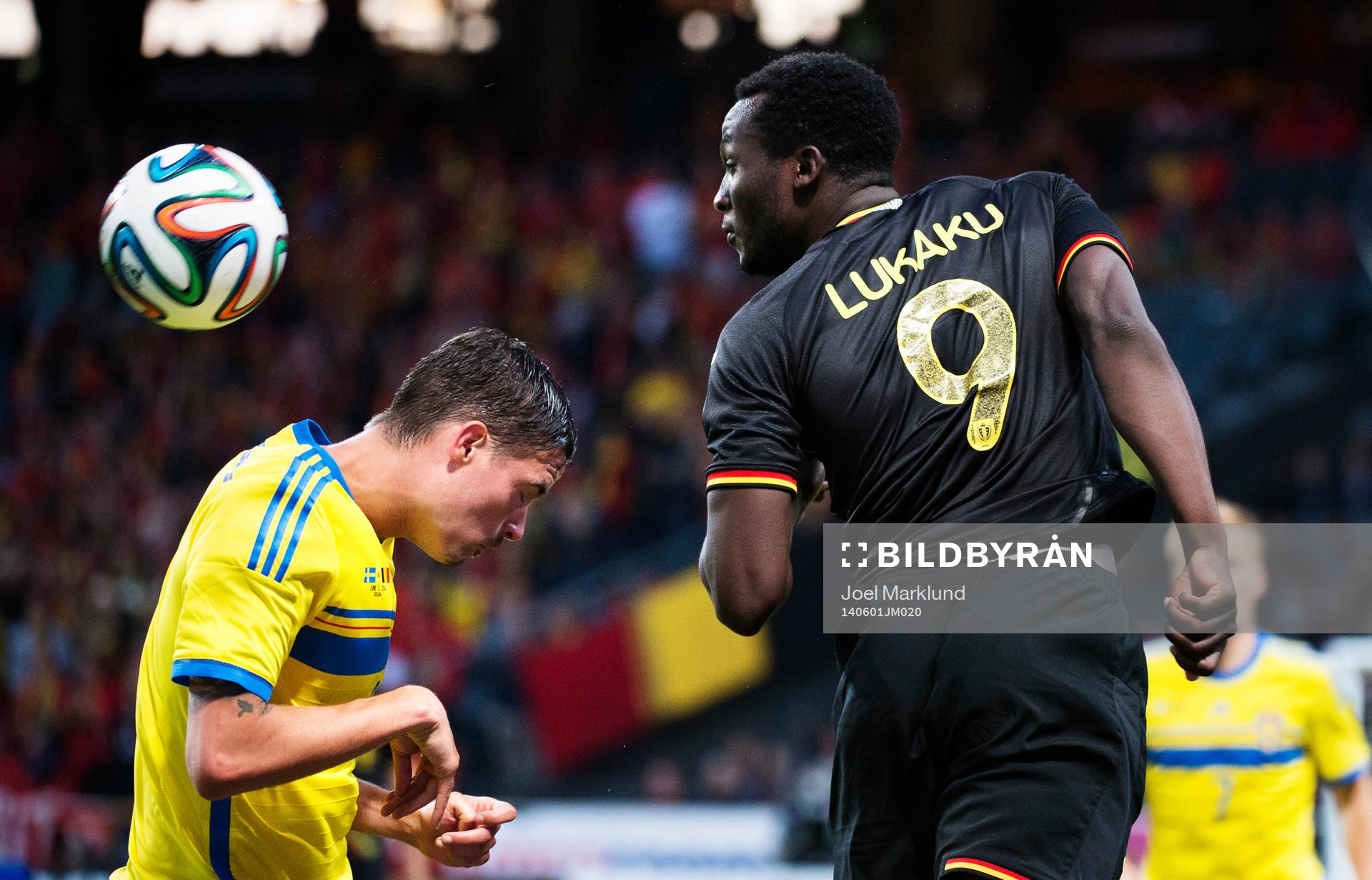Sveriges Mikael Lustig förlorar en nickduell med Belgiens
