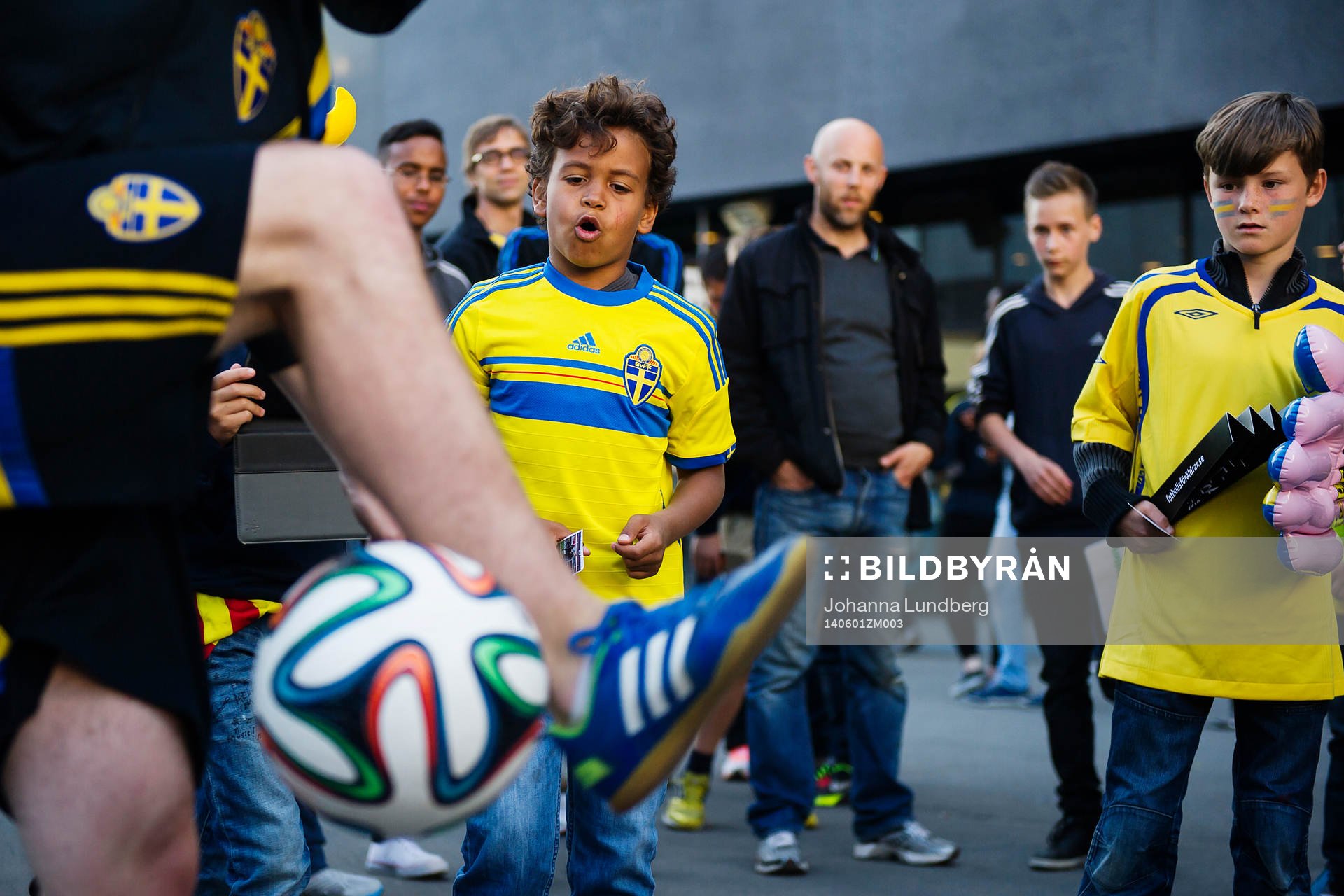 En ung kille är imponerad över en man som kickar med en