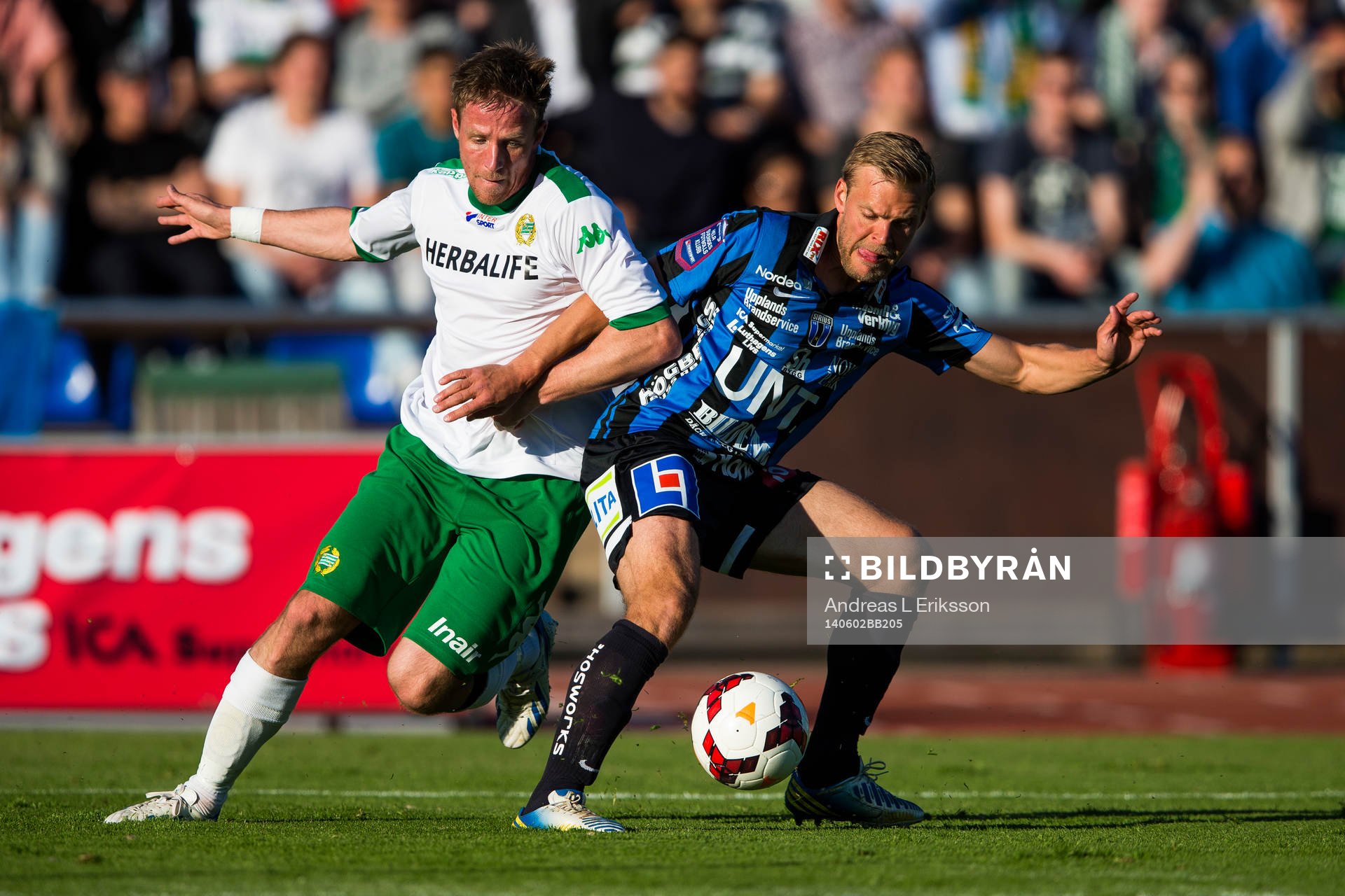 Hammarbys Jan Gunnar Solli i kamp om bollen med Sirius Johan Arneng under fotbollsmatchen i Superettan mellan Sirius och Hammarby den 2 juni 2014 i Stockholm.
