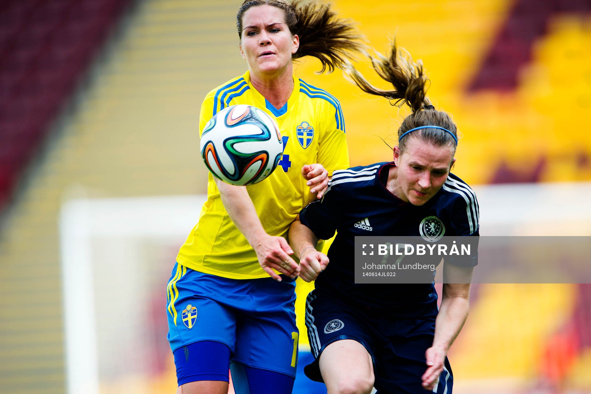 Sveriges Hanna Folkesson i kamp med Skottlands Frankie Fantom-Brown under fotbollsmatchen i VM-kvalet mellan Skottland och Sverige den 14 juni 2014 i Motherwell.