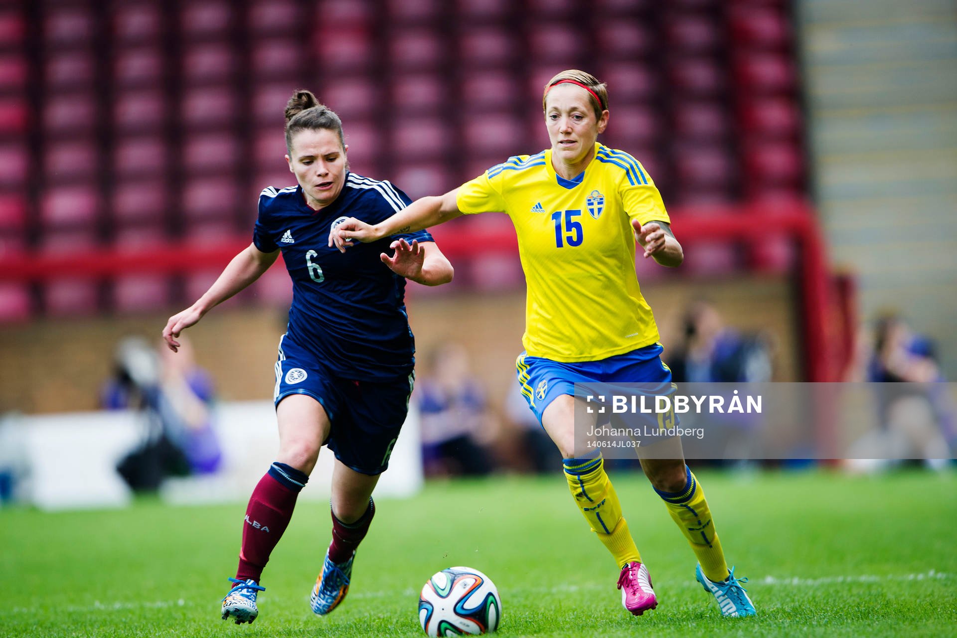 Skottlands Joanne Love i kamp med Sveriges Therese Sjögran under fotbollsmatchen i VM-kvalet mellan Skottland och Sverige den 14 juni 2014 i Motherwell.