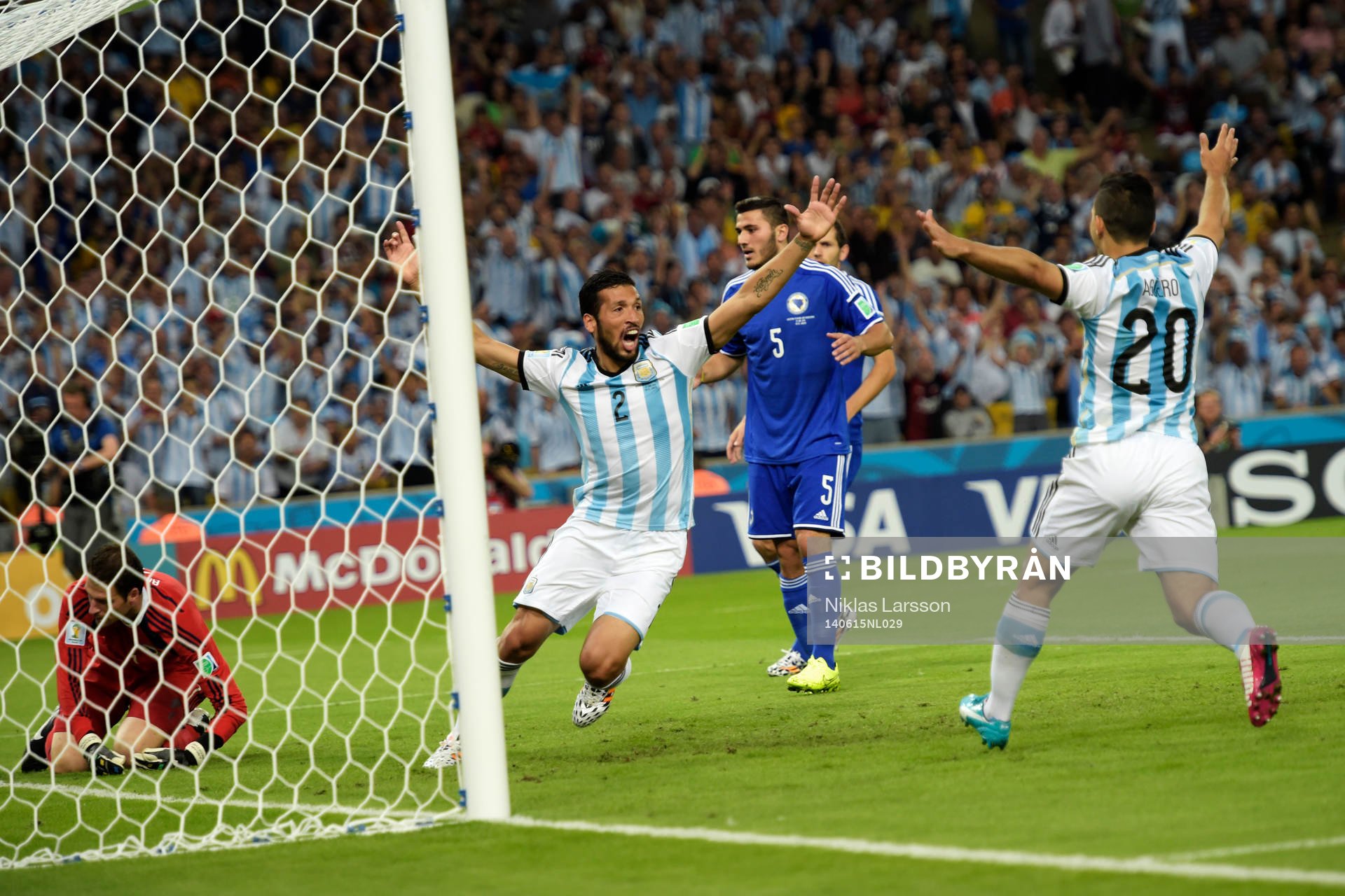 Argentinas Ezequiel Garay och Sergio Aguero jublar efter ett självmål under fotbollsmatchen mellan Argentina och Bosnien under Fotbolls-VM den 15 juni 2014 i Rio de Janeiro.