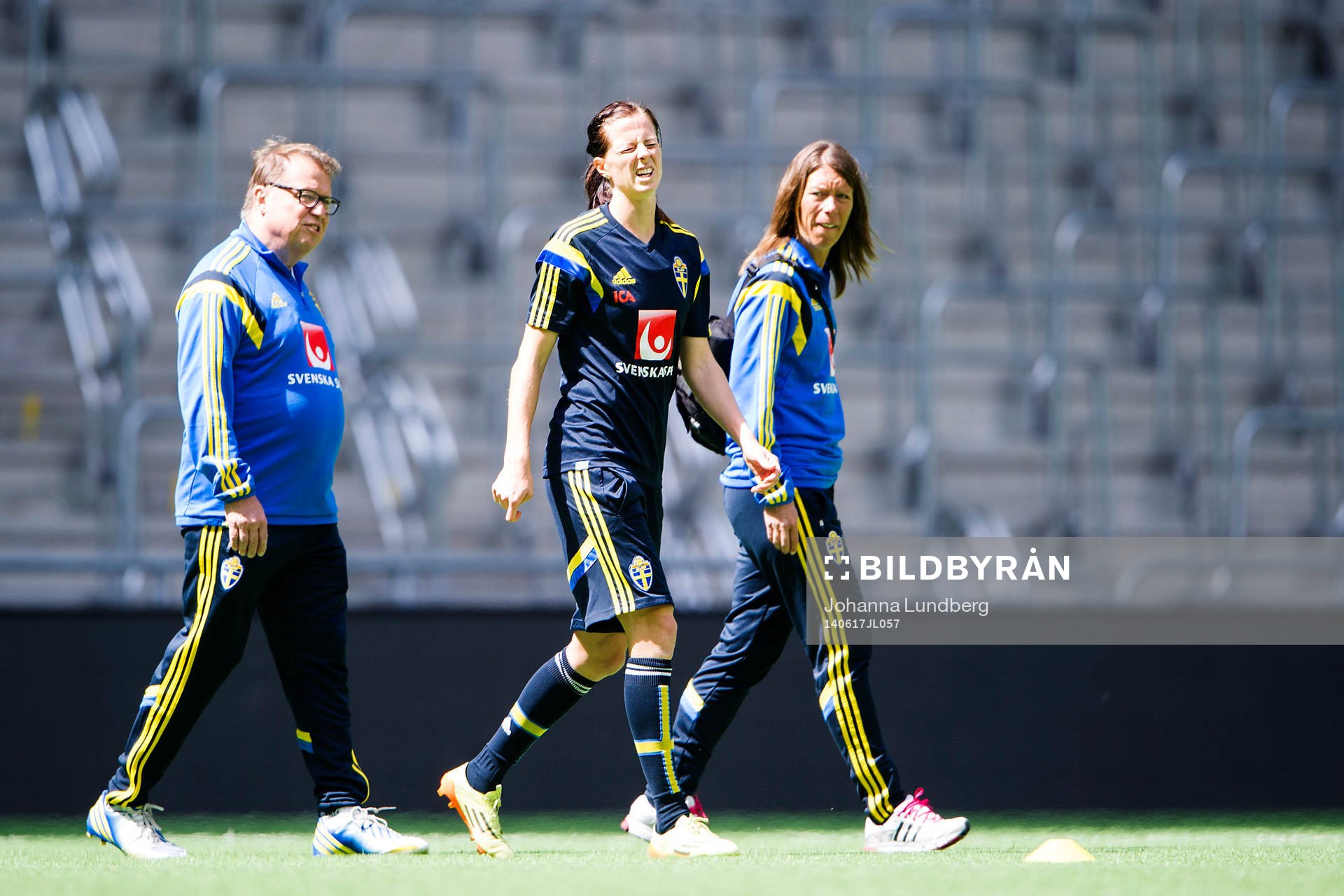 Sveriges Lotta Schelin har ont och går av planen tillsammans med läkare Yelverton Tegner och sjukgymnast Karin Schröder under en träning inför VM-kvalmatchen mot Färöarna den 16 juni 2014 i Stockholm.