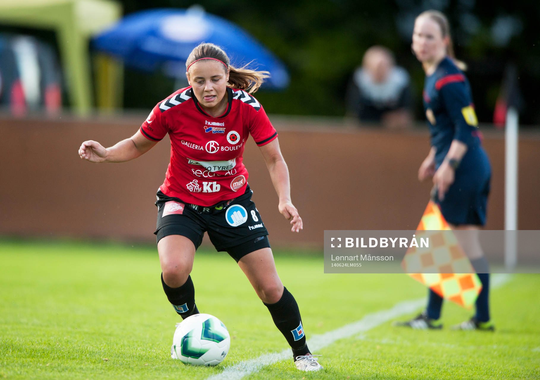 Kristianstads Alice Nilsson räddar bollen under överinseende av assisterande domaren i matchen i damallsvenskan mellan Kristianstad och Örebro i Kristianstad 24 juni.