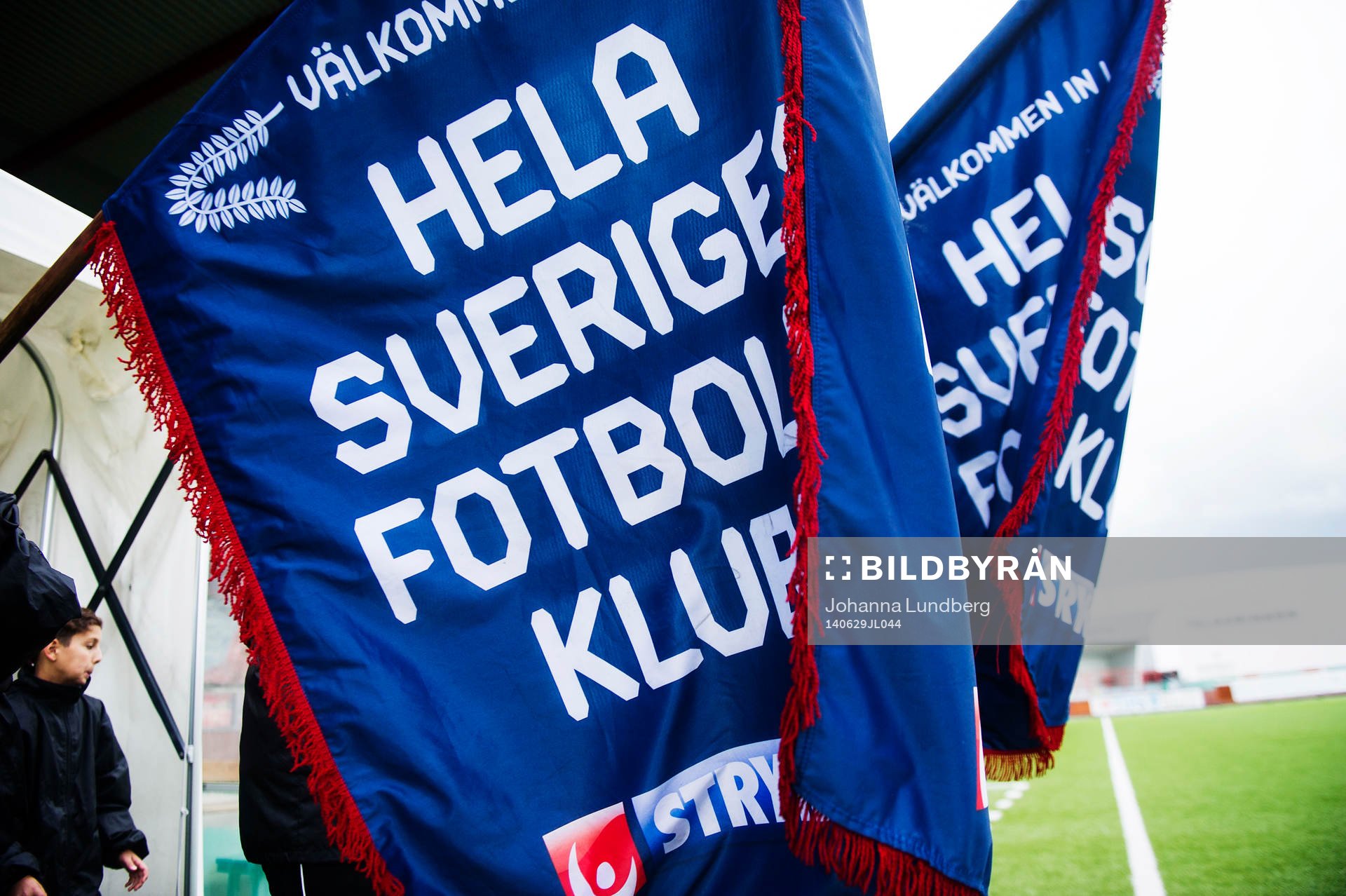 Matchknattar går ut med stryktipset flaggor under fotbollsmatchen i Superettan mellan Syrianska och Degerfors den 29 juni 2014 i Södertälje.