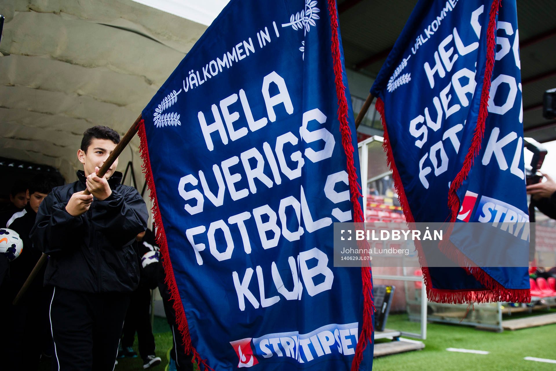 Matchknattar går ut med stryktipset flaggor under fotbollsmatchen i Superettan mellan Syrianska och Degerfors den 29 juni 2014 i Södertälje.