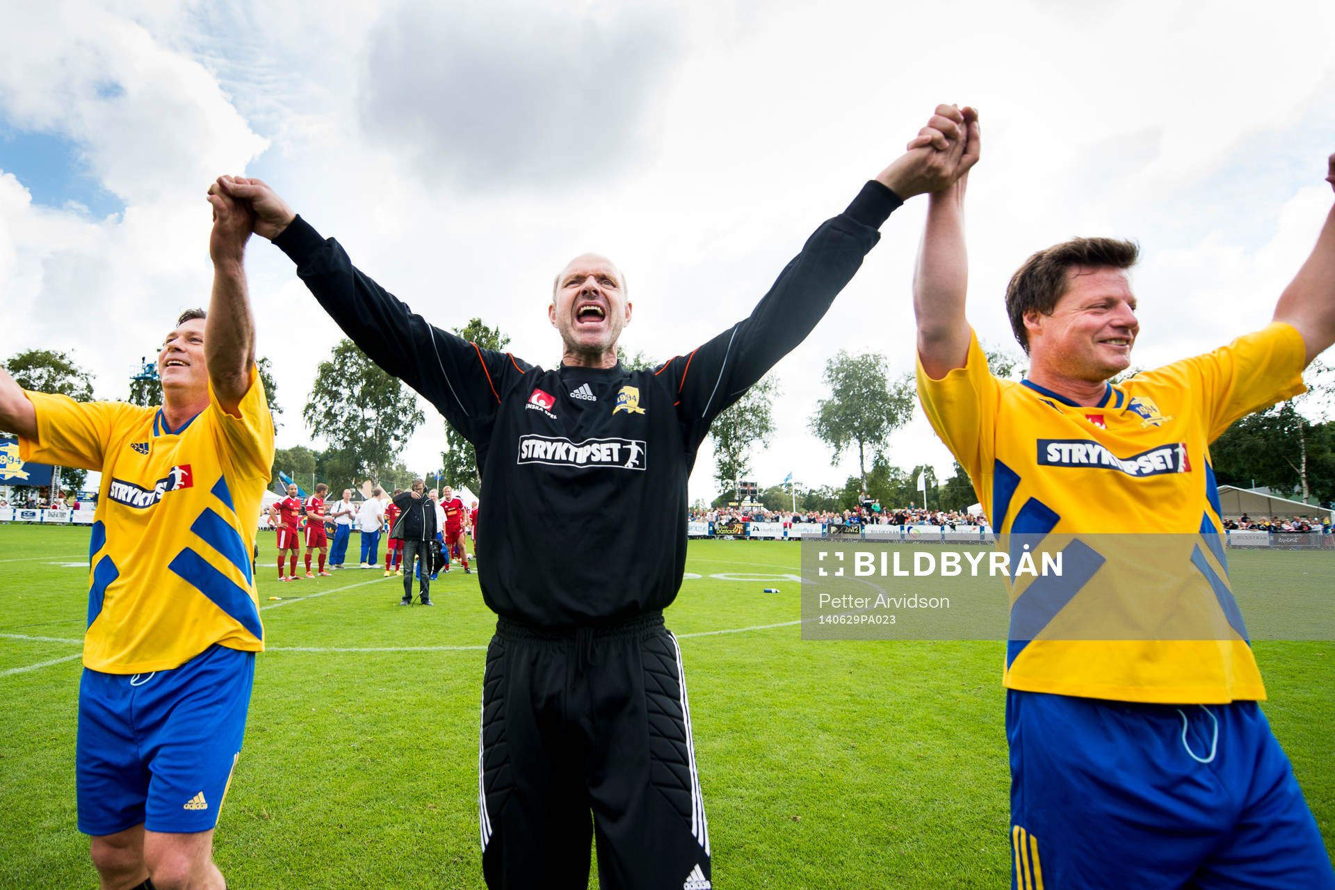VM-laget 1994s Pontus Kåmark (tv), målvakt Thomas Ravelli (m) och Stefan Schwarz (th) tackar publiken efter 20-års jubileumsmatchen mellan VM-laget 1994 och Motståndarlaget den 29 juni 2014 i Båstad.