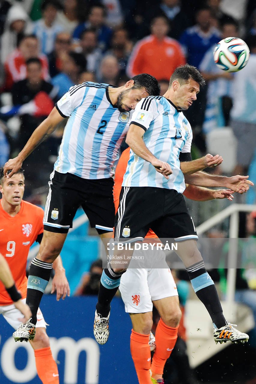 Argentinas Ezequiel Garay och Fernando Gago under semifinalen mellan Argentina och Holland under fotbolls-VM den 9 juli 2014 i Sao Paulo.