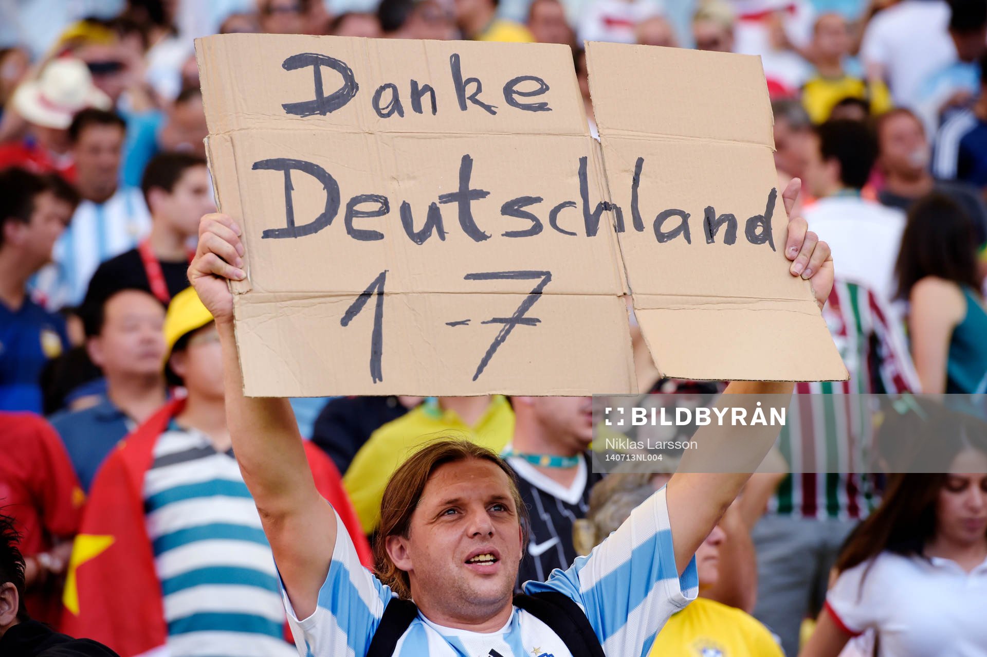 En Argentinsk supporter håller upp en skylt som tackar det