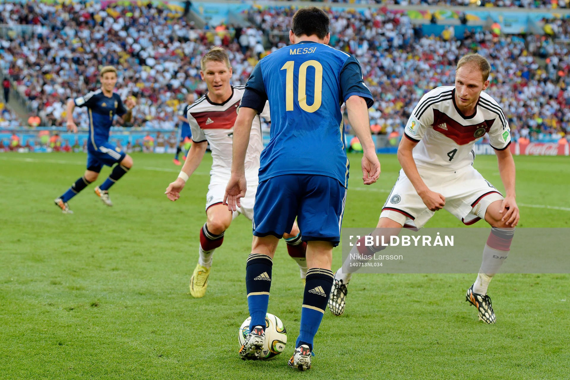 Tysklands Bastian Schweinsteiger och Benedikt Hoewedes markerar Argentinas Lionel Messi under finalen mellan Argentina och Tyskland under fotbolls-VM den 13 juli 2014 i Rio de Janeiro.
