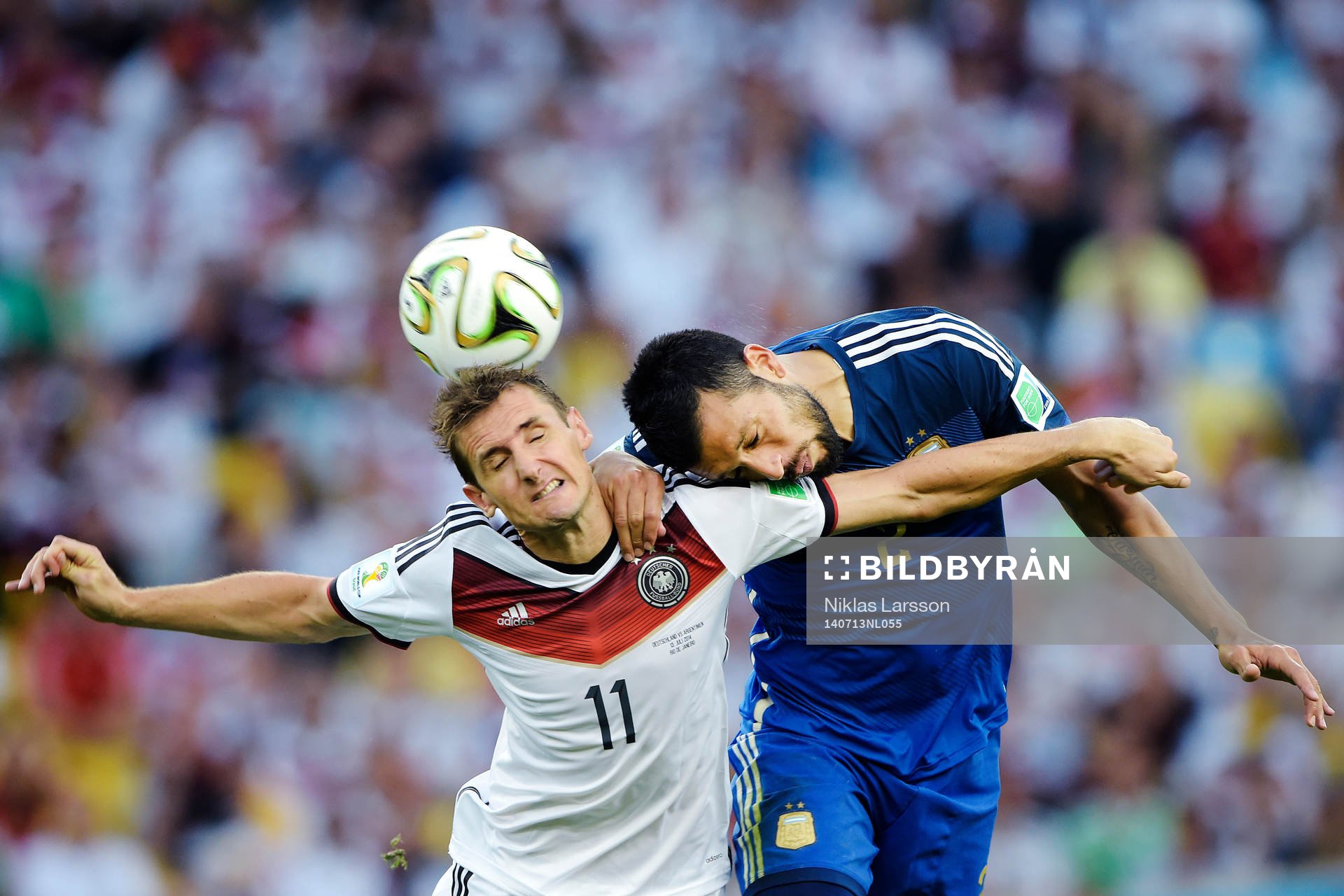 Tysklands Miroslav Klose i en luftduell mot Argentinas