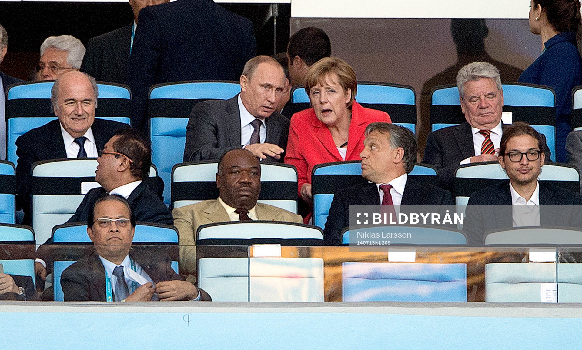 Rysslands president Vladimir Putin samtalar med Tysklands förbundskansler Angela Merkel och FIFAs president Sepp Blatter till vänster under finalen mellan Argentina och Tyskland under fotbolls-VM den 13 juli 2014 i Rio de Janeiro.